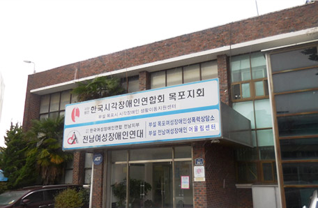 목포시각장애인생활이동지원센터 건물 측면으로 입구간판에는 한국시각장애인연합회 목포지회,전남여성장애인연대 간판이 걸려있는 모습