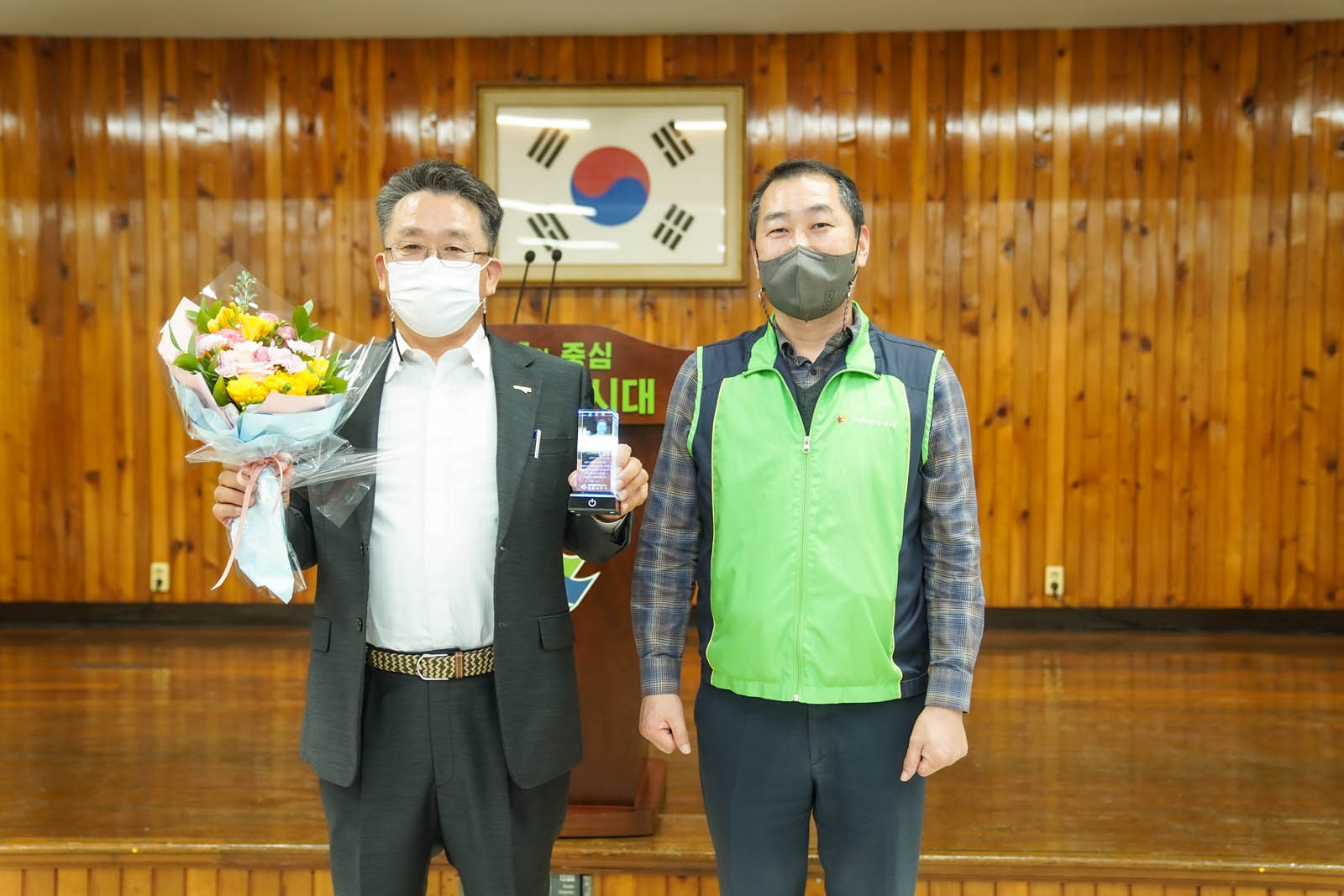 (03.31.회의실) 목포시공무원노조 두명이 꽃다발과 상을 들고 기념촬영모습