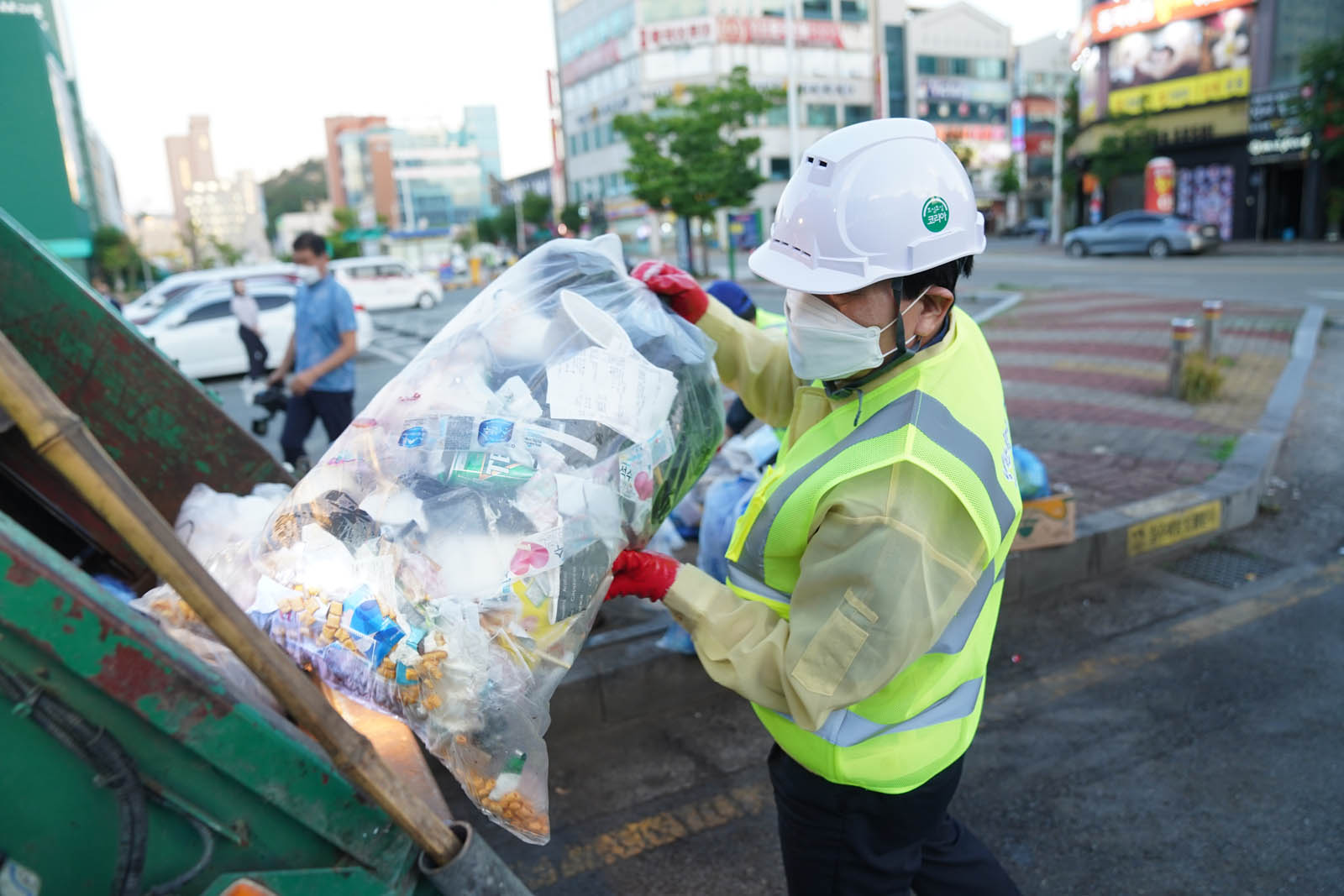 (07.01.빅마트일원) 쓰레기가 담긴 봉투를 쓰레기차에 정리하는 목포시장의 모습