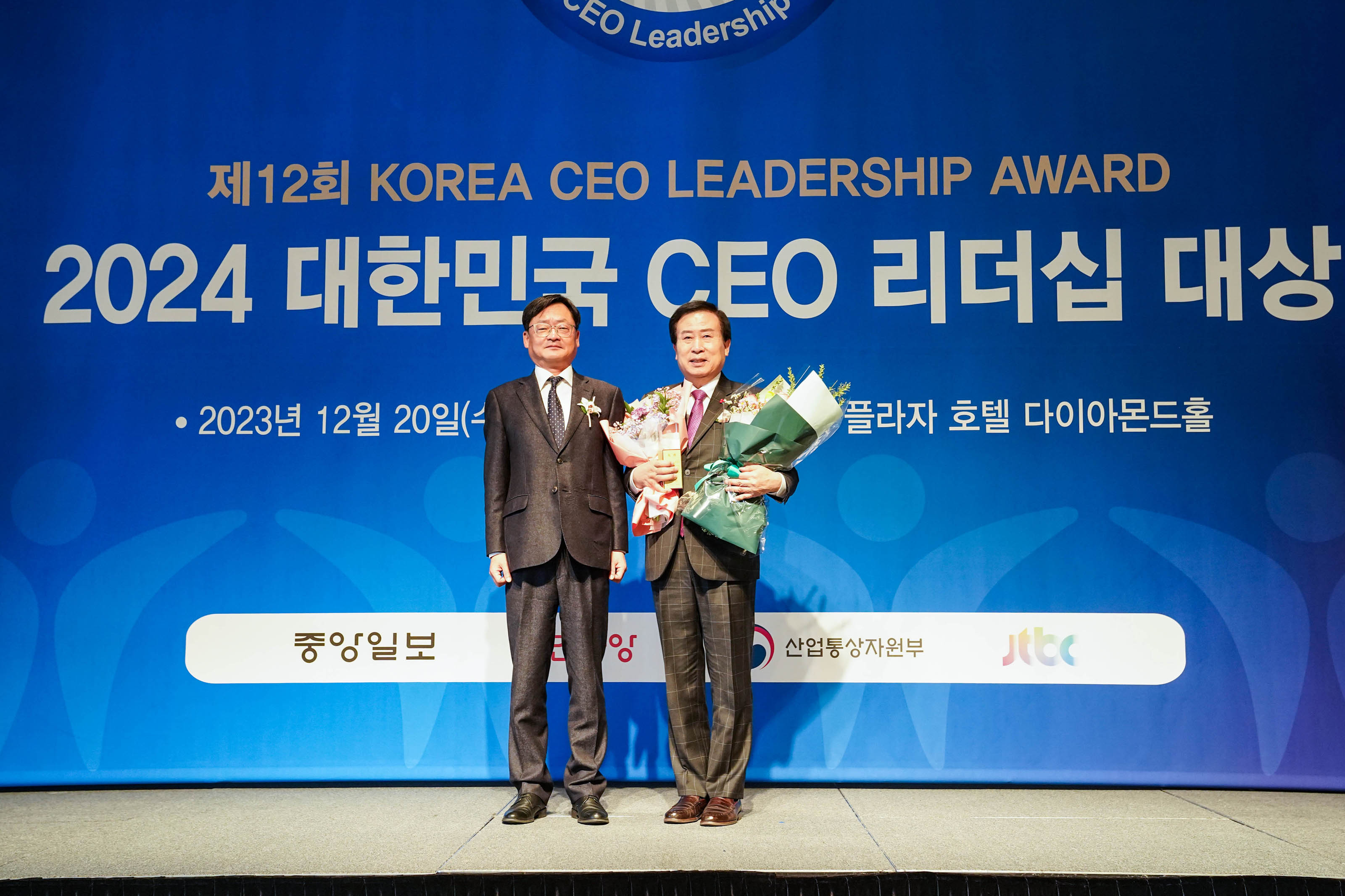 제 12회 KOREA CEO LEADERSHIP AWARD 2024 대한민국 CEO 리더쉽 대상 배경을두고 단상위에서 꽃을 든 목포시장 박홍률과 관계자