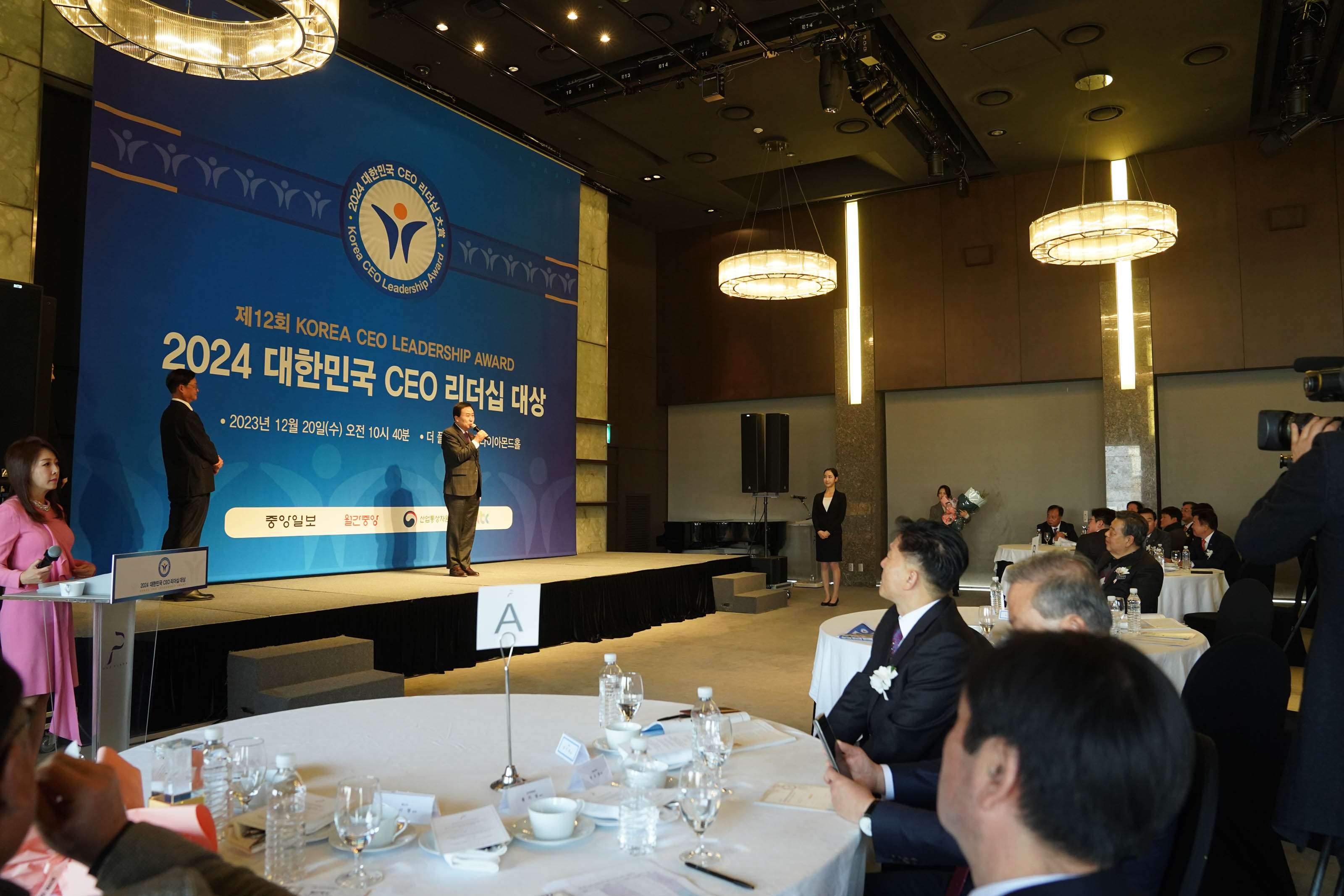 제 12회 KOREA CEO LEADERSHIP AWARD 2024 대한민국 CEO 리더쉽 대상 배경을두고 단상위에서 발표하는 목포시장 박홍률과 집중하는 청중