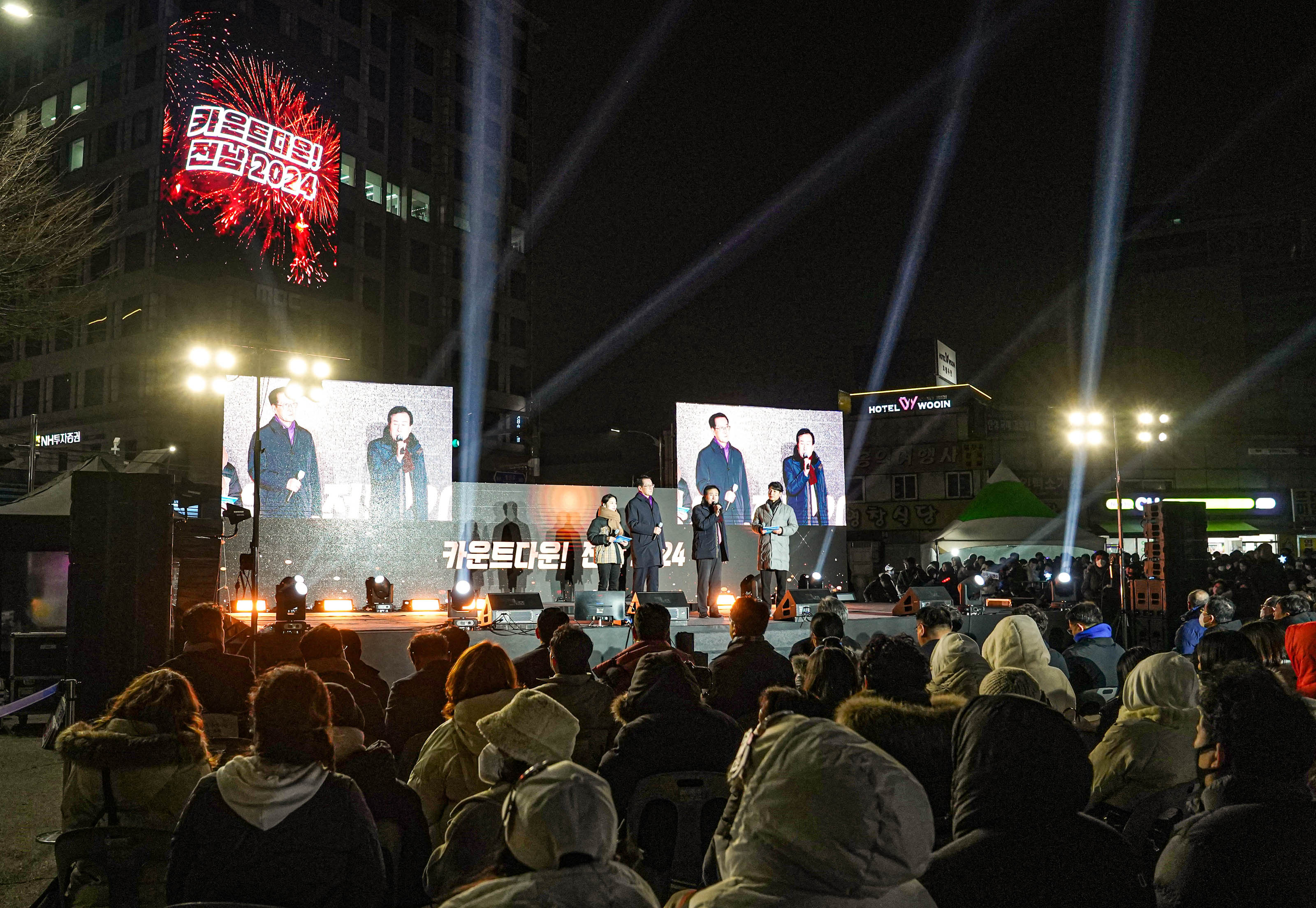 카운트 다운 전남 2024가 적혀있는 건물 광고대 앞 무대에서 마이크를 들고 이야기중인 목포시장 박홍률과 경청하는 청중들