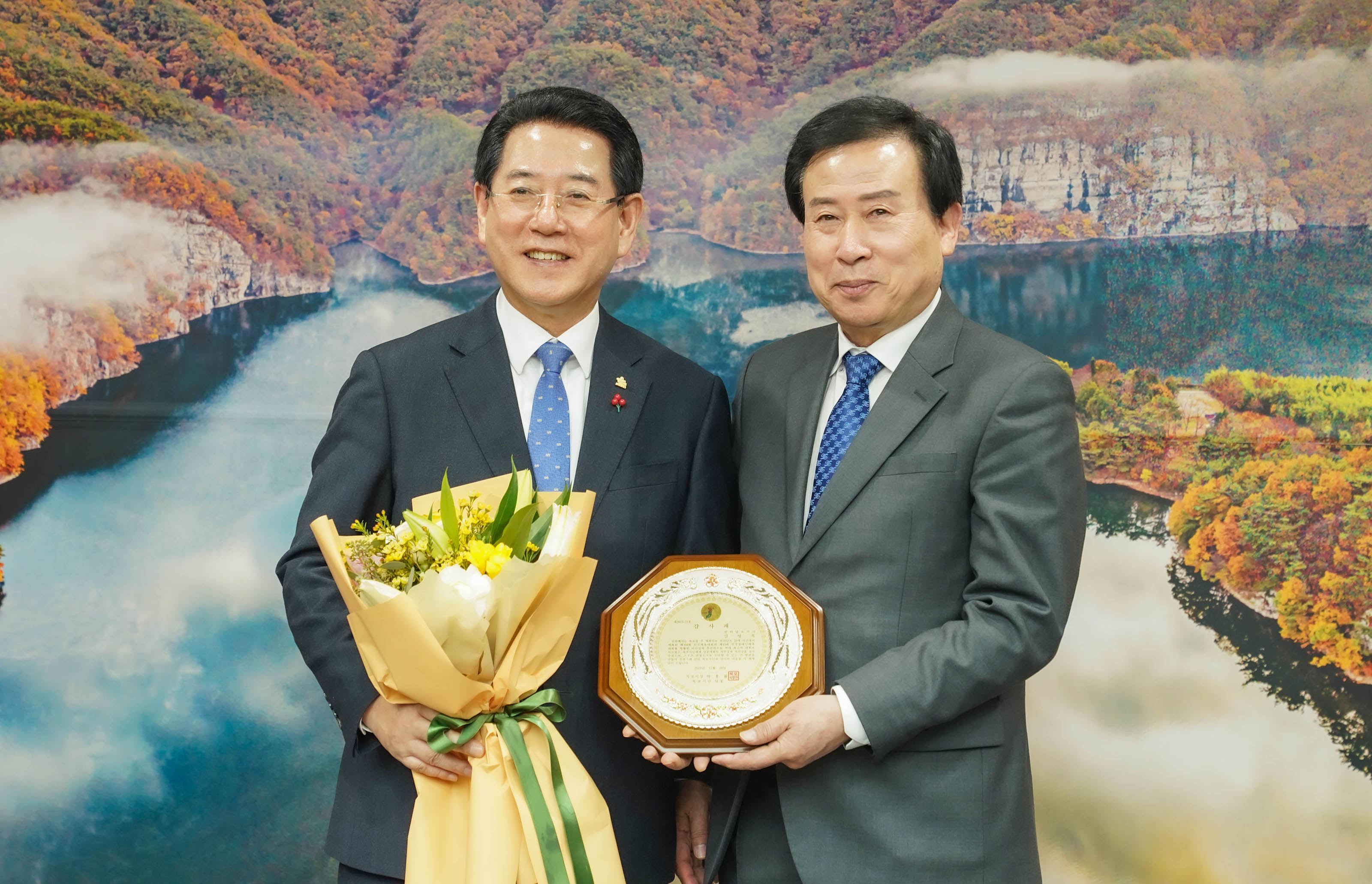 감사패를 들고있는 박홍률 시장과 꽃을 들고있는 관계자
