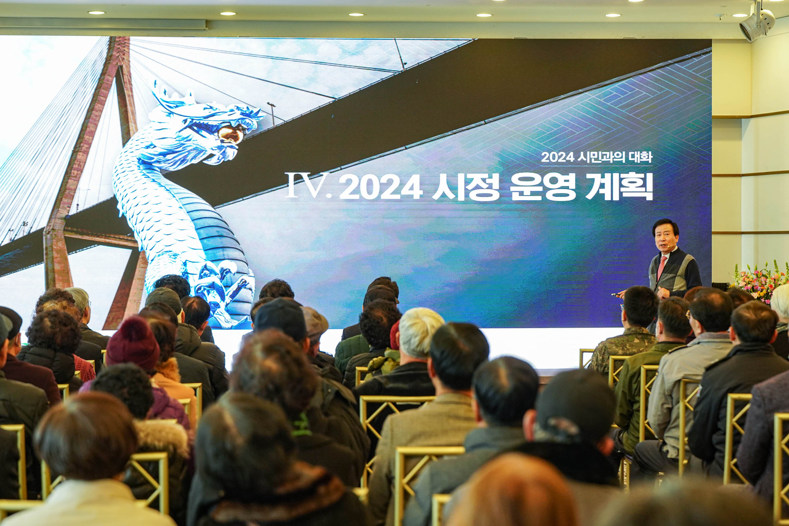 2024 시만과의 대화 2024 시정운영계획 글을 배경으로 두고 시민들과 소통중인 박홍률 시장과 경청중인 시민들
