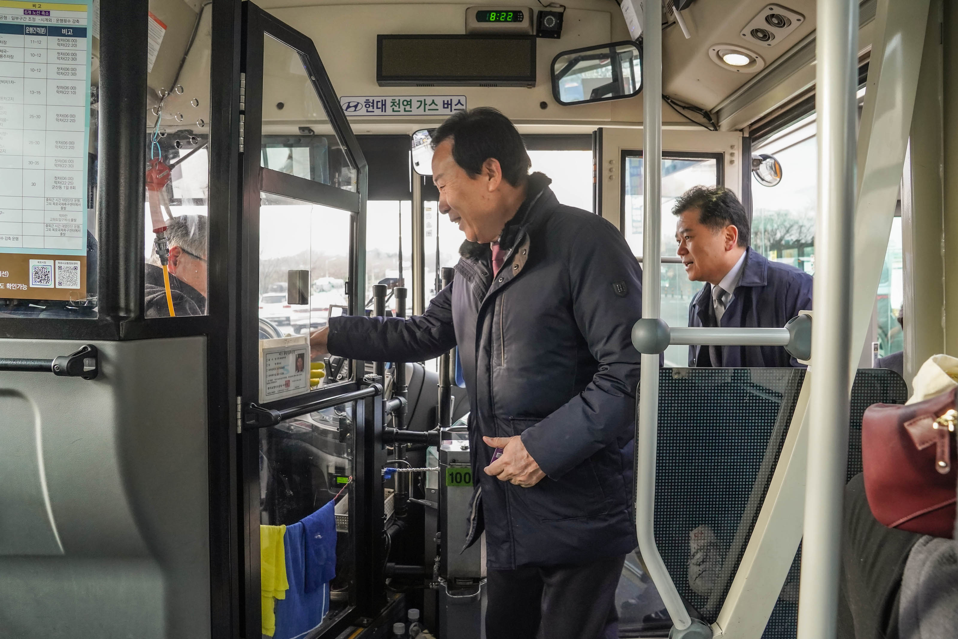 시내버스를 오르며 버스 기사님과 악수를 하며 인사하는 박홍률 시장의 모습. 그 뒤로 의원으로 보이는 남성이 뒤따라 올라타고 있다.