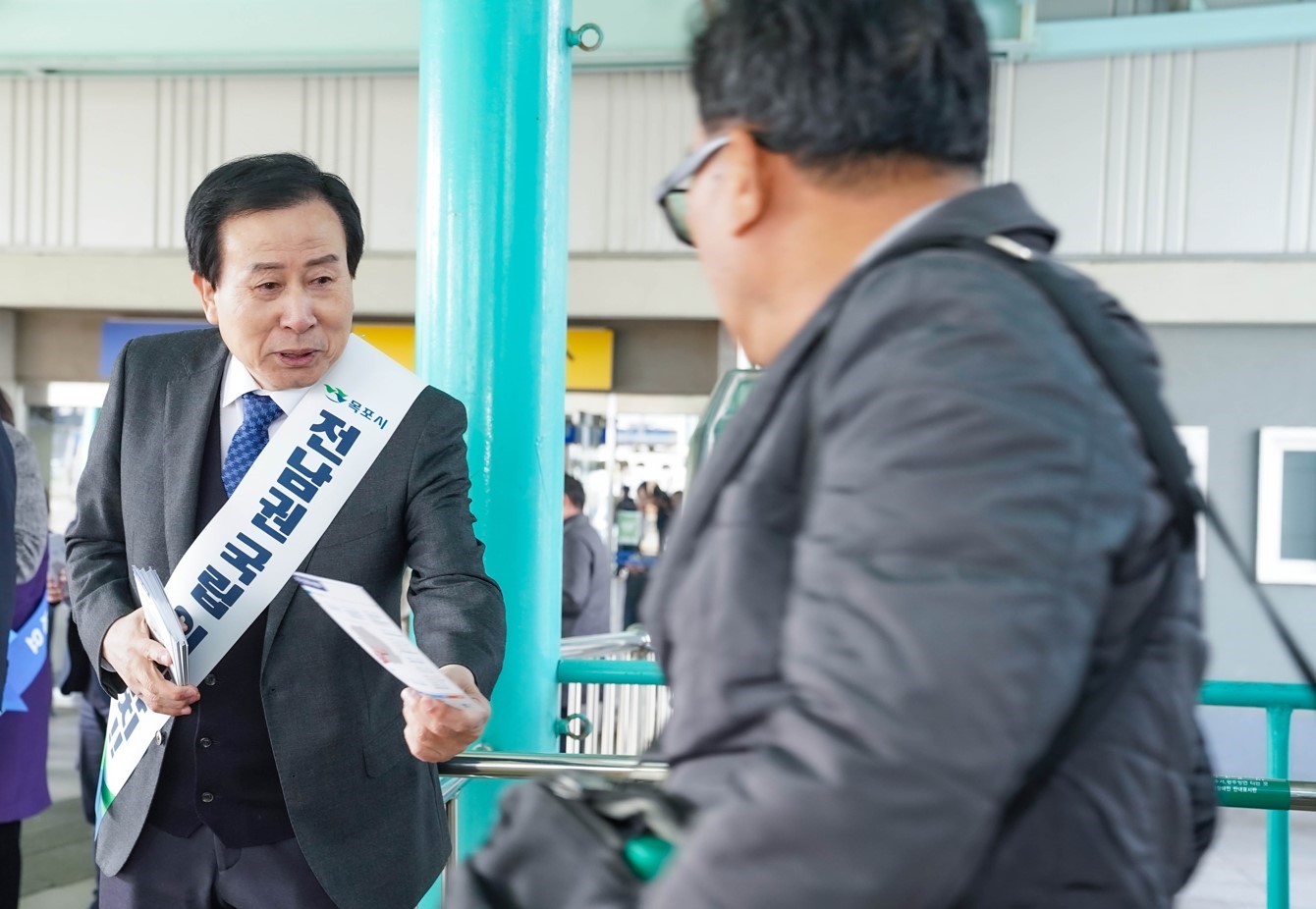 박홍률 목포시장이 전남권 국립 의대 유치 띠를 매고 시민들에게 전단지를 나눠주는 모습