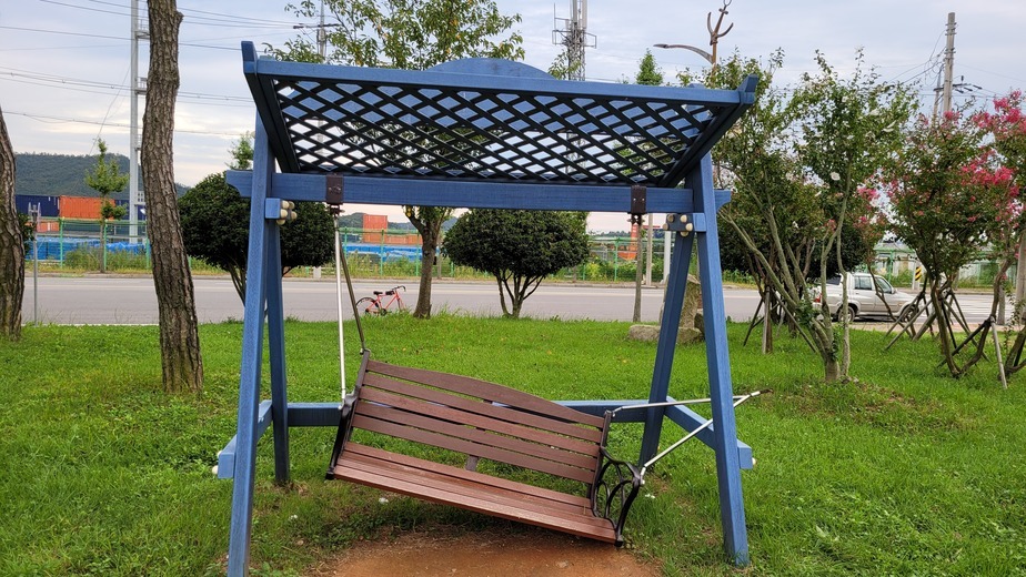 잔디위에 있는 그네형 벤치 연결부위가 끊어져 있는 앞쪽모습