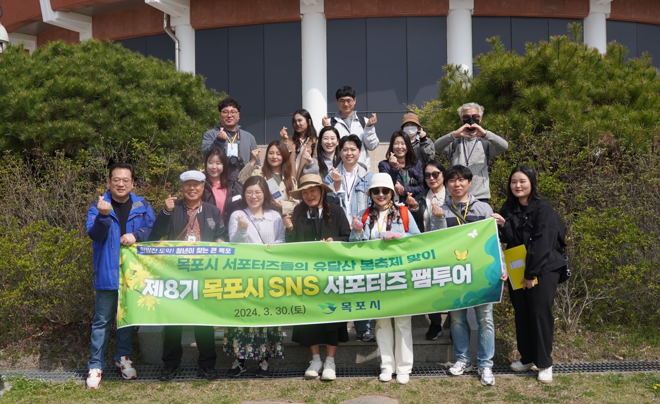 목포시 제8기 SNS서포터즈가 현수막(희망찬 도약! 청년이 찾는 큰 목포 목포시 서포터즈들의 유달산 봄축제 맞이 제8기 목포시 SNS서포터즈 팸투어 2024.3.30(토) 목포시)을 들고 손하트를 하며 기념촬영을 하는 모습