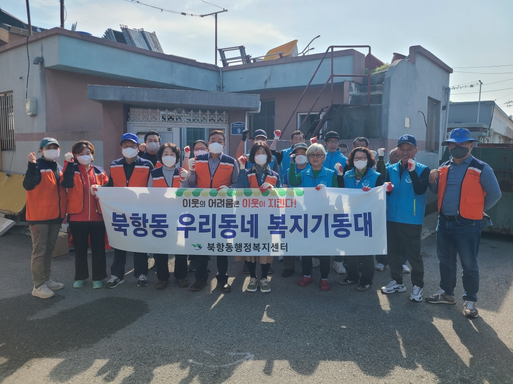 이웃의 어려움은 이웃이 지킨다! 북항동 우리동네 복지기동대 북항동행정복지센터 문구가 적힌 현수막을 들고 있는 소 전문업체 목포희망드림센터와 북항동 지역사회보장협의체(위원장 최상식), 복지기동대원 등 20명의 사람들이 마스크를 끼고, 화이팅을 하며 찍은 단체사진