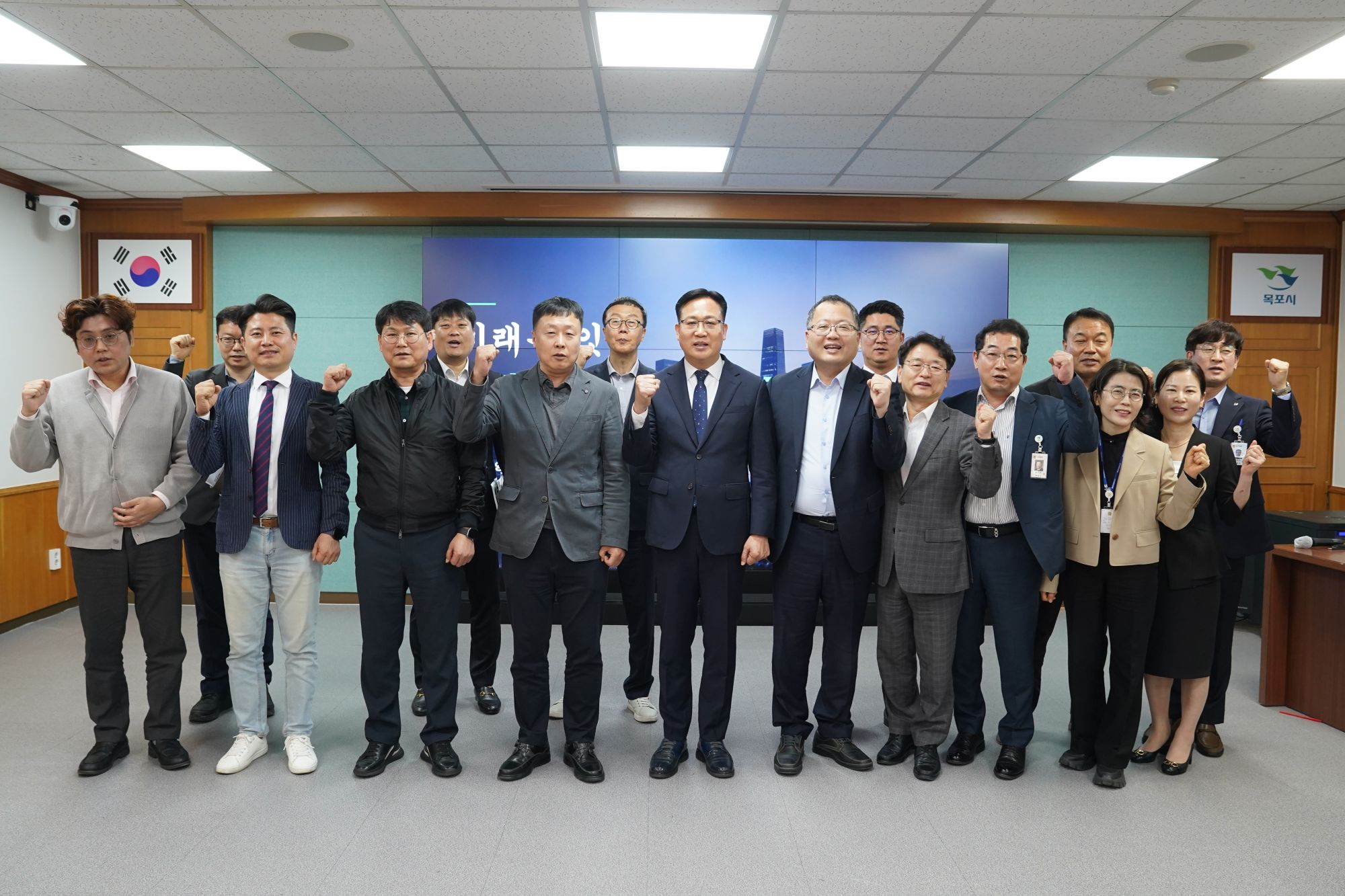 화이팅을 하며 카메라를 바라보고 있는 교통행정과 직원 16명의 단체사진