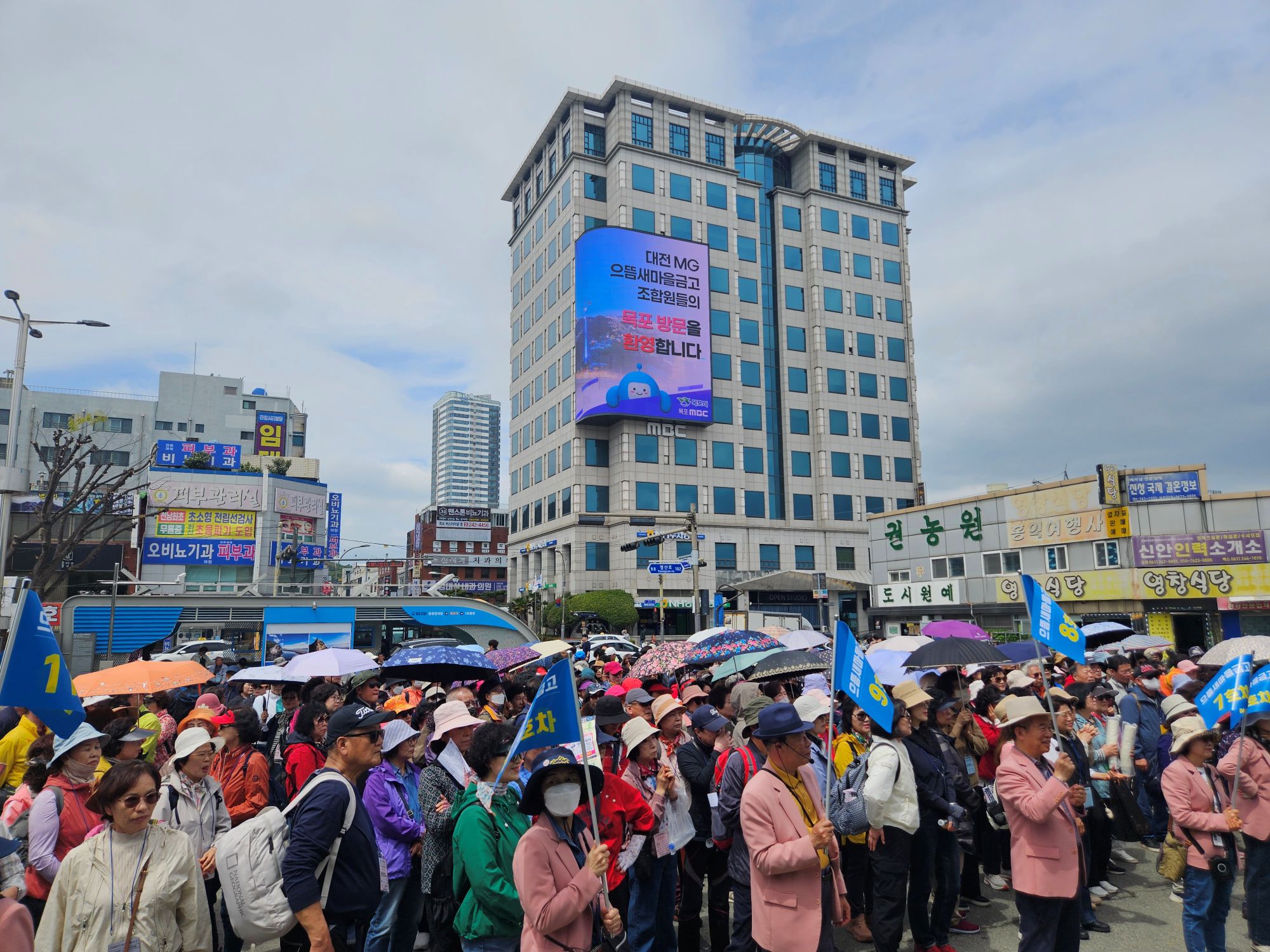 목포역 일대에 으뜸새마을금고 회원교육 기차여행을 위해 안내원들과 시민들이 단체로 모여있다.
