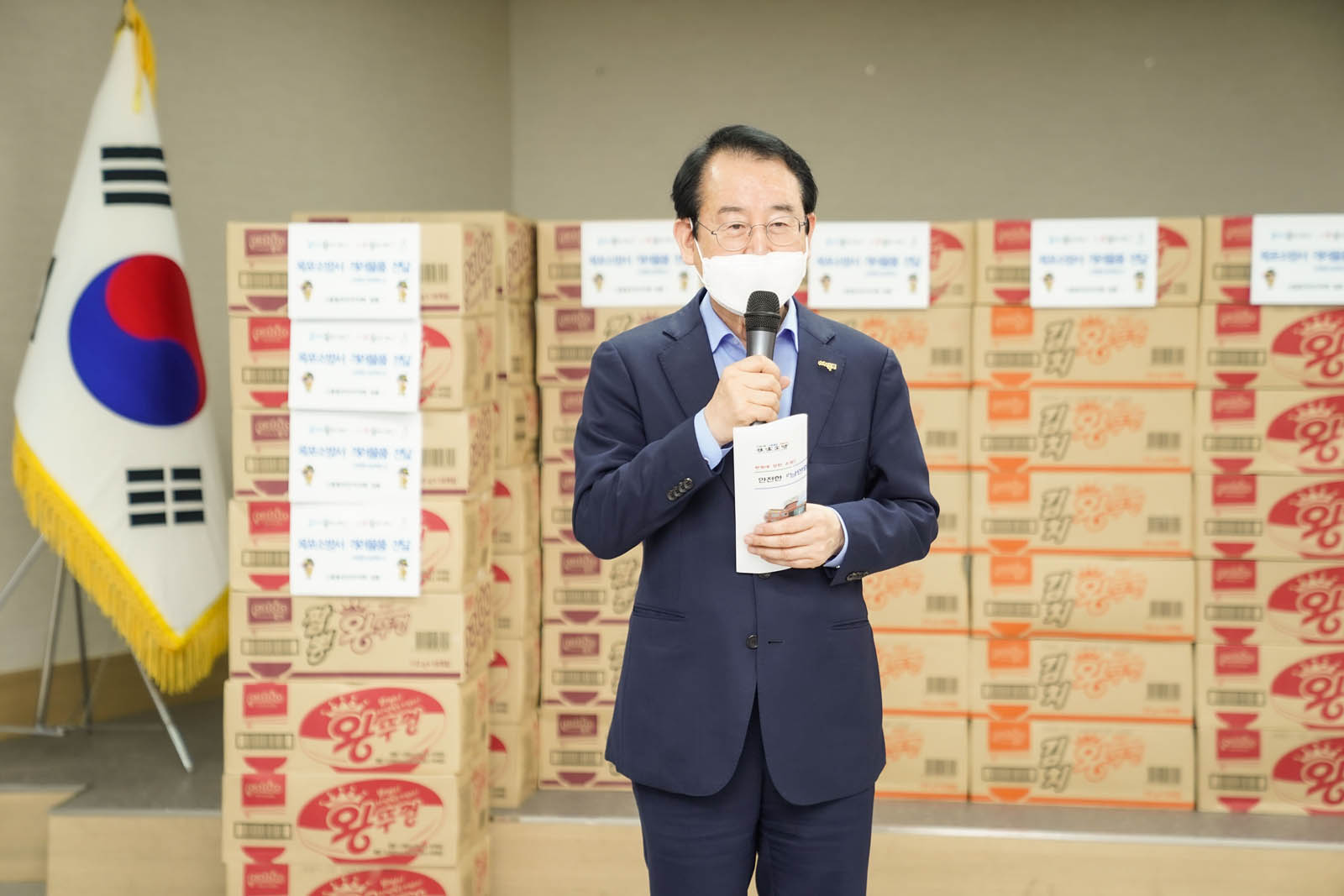 목포소방서 소방대원 격려 기념품이 뒤에 쌓여 있고 앞에 시장님이 서서 연설을 하고 있다