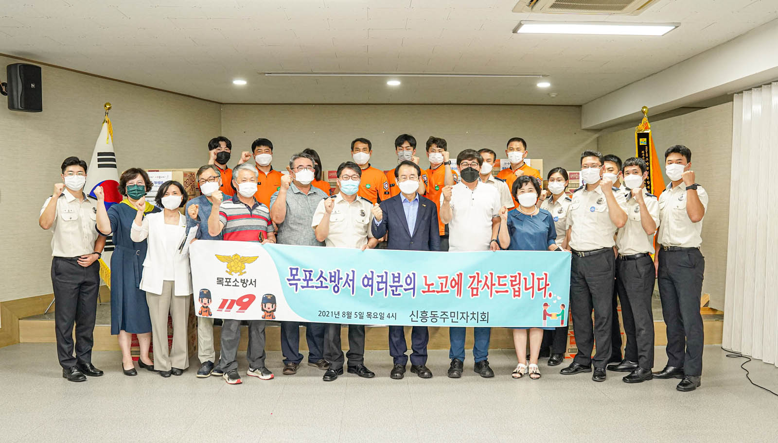 소방대원들과 관계자들 시장님이 목포소방서 여러분의 노고에 감사드립니다 라고 적힌 현수막을 들고 기념 촬영을 하고 있다