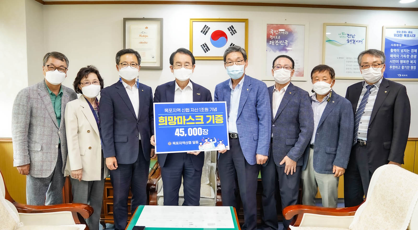 시장님과 관계자 여러 명이 사무실에서 기념사진을 찍고 있다.