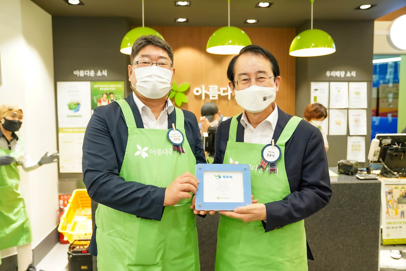 가게 인증 마크를 들고 시장님과 포즈를 취하고 있다