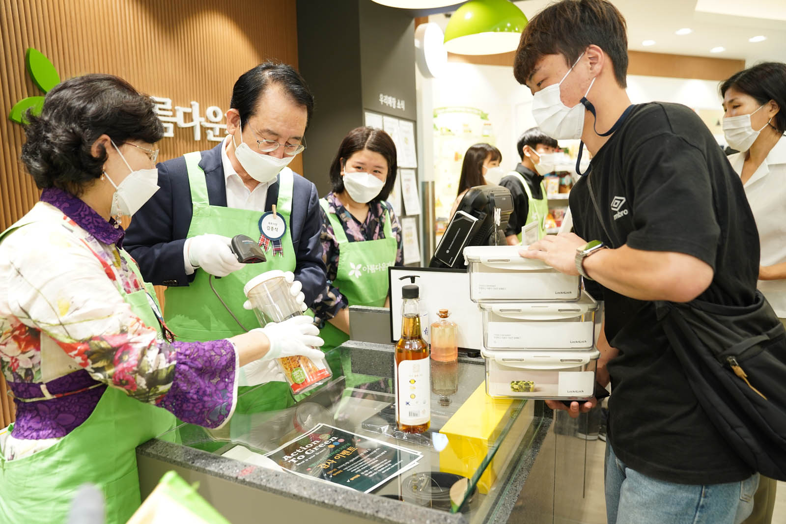 시장님이 손님이 구매한 물건에 바코드를 찍고 있는 모습이다.