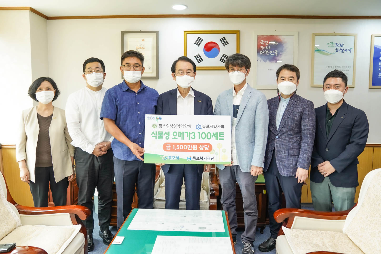 팜스임상영양약학회 목포시약사회 식물성 오메가3 100세트 금 1,500만원 상당 이라고 적힌 배너를 들고 기념사진을 찍고 있다.