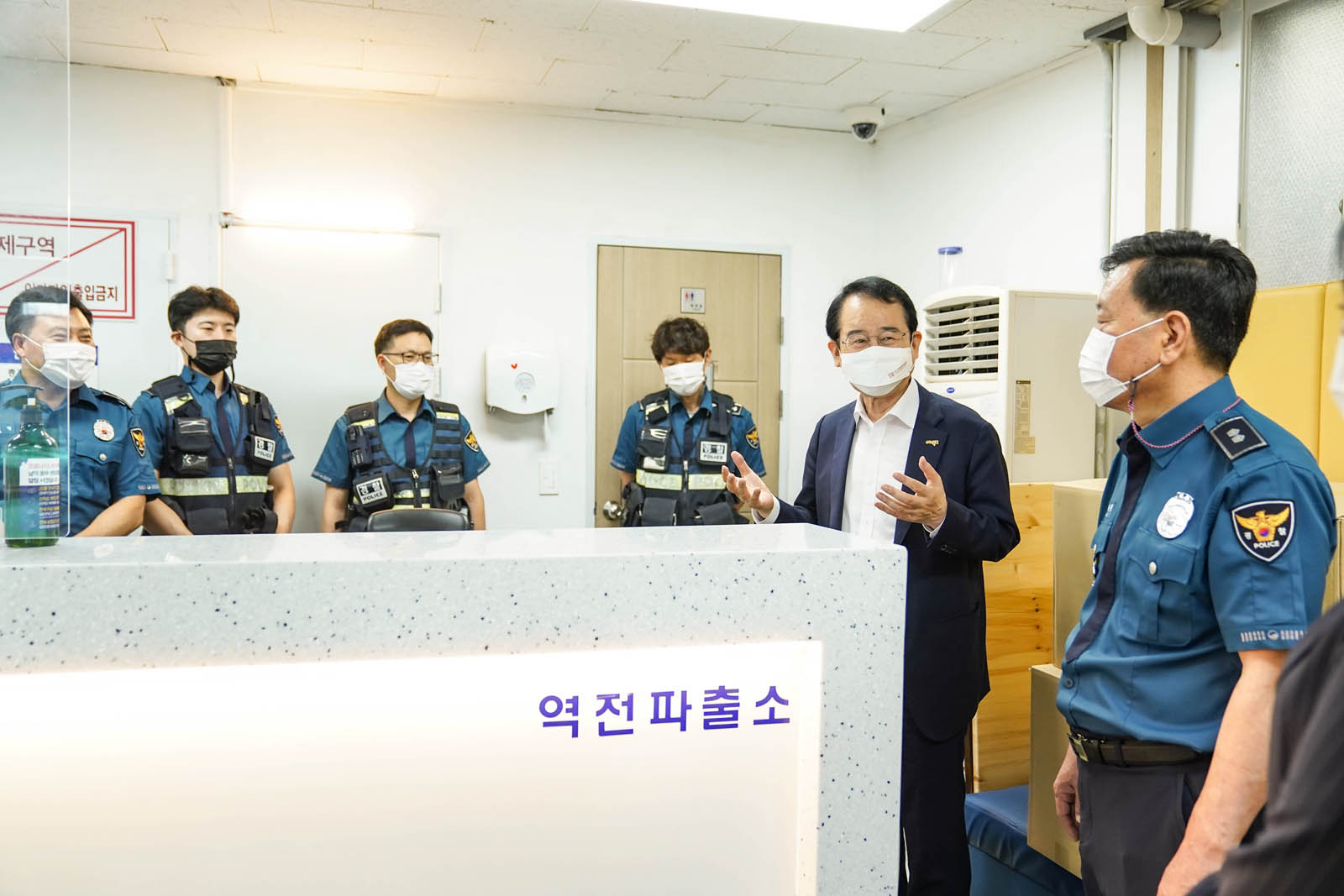 역전파출소 내에서 제복을 입은 경찰 여러 명과 시장님이 이야기를 나누고 있는 사진이다