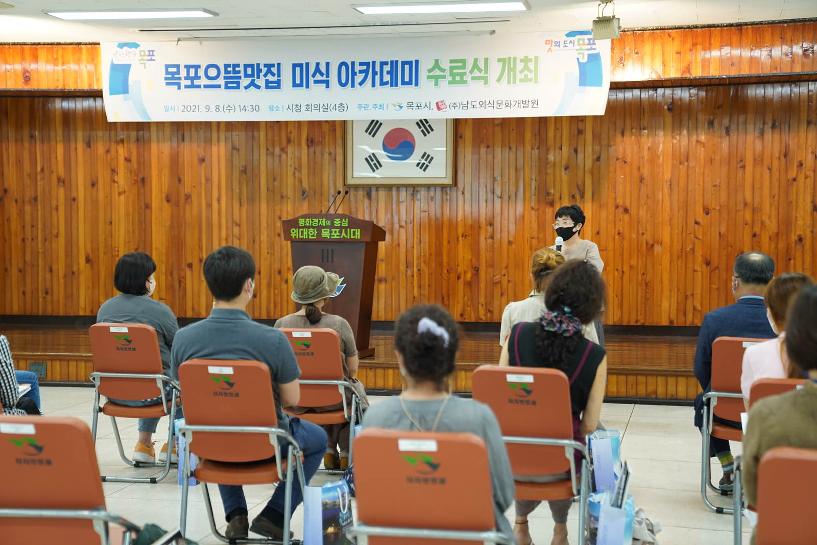 목포으뜸맞십 미식 아카데미 수료식 개최라고 적힌 현수막이 걸려 있고 강사가 앞에서 강의하고 있다.