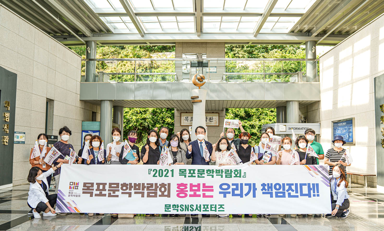 [2021 목포문학박람회] 목포문학박람회 홍보는 우리가 책임진다! 문학SNS서포터즈 라고 적힌 현수막을 들고 기념사진을 촬영하고 있다