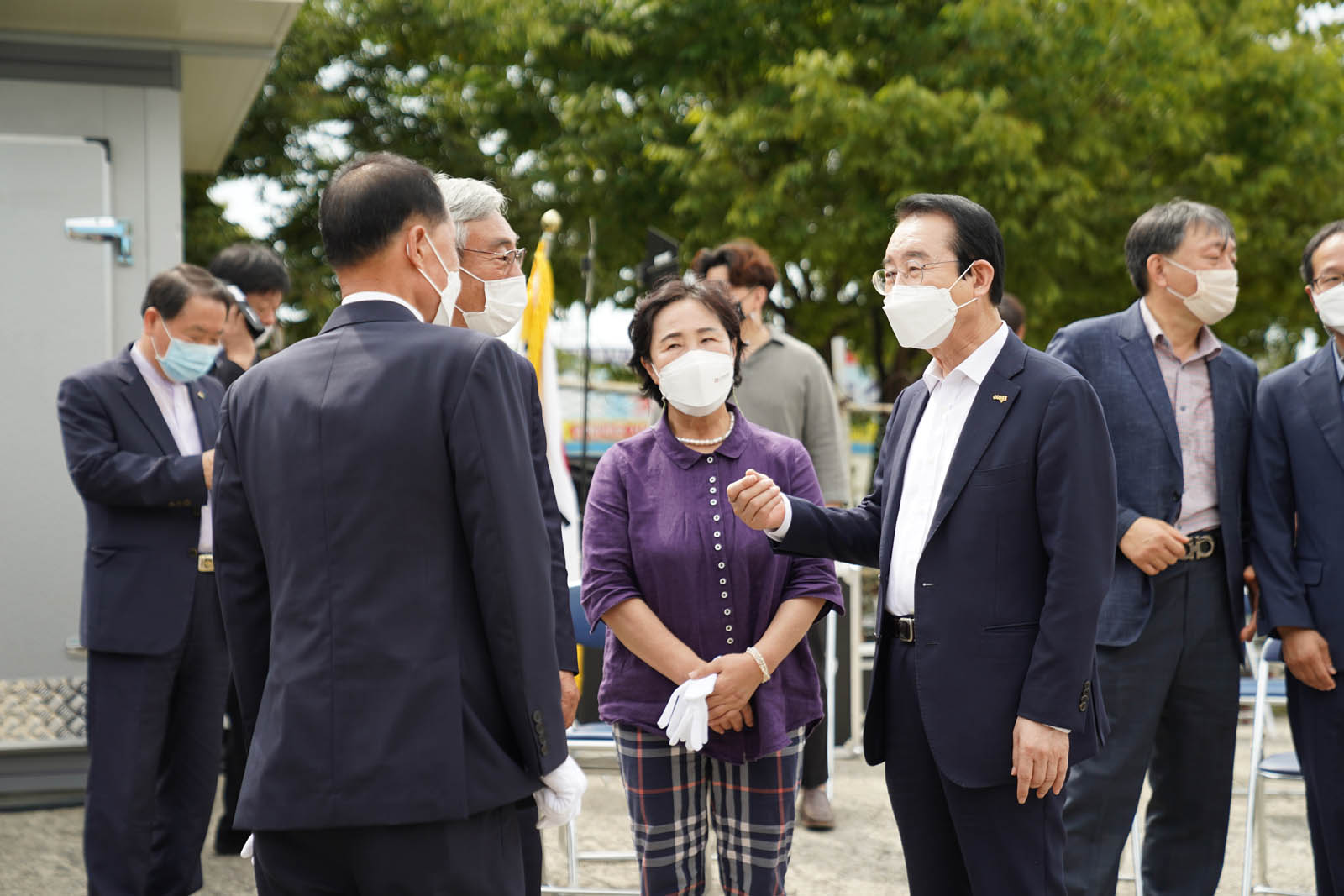 시장님과 관계자들이 둥글게 서서 서로 바라보며 이야기 나누고 있다