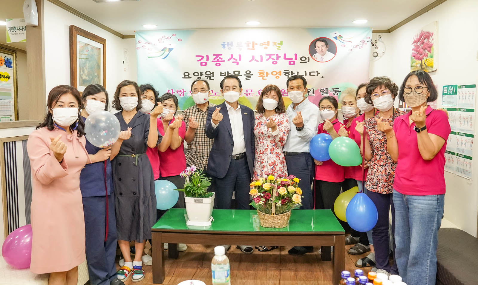 복지시설 관계자들과 손가락하트를 하고 찍은 기념사진이다