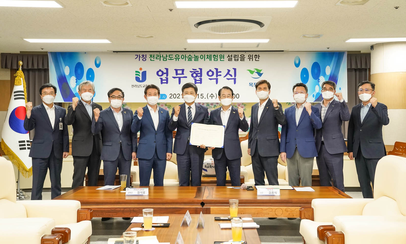 전라남도 유아숲 놀이체험원 설립 업무협약 체결식 후 시장님과 관계자들이 모두 모여 화이팅을 하며 기념촬영을 하고 있다