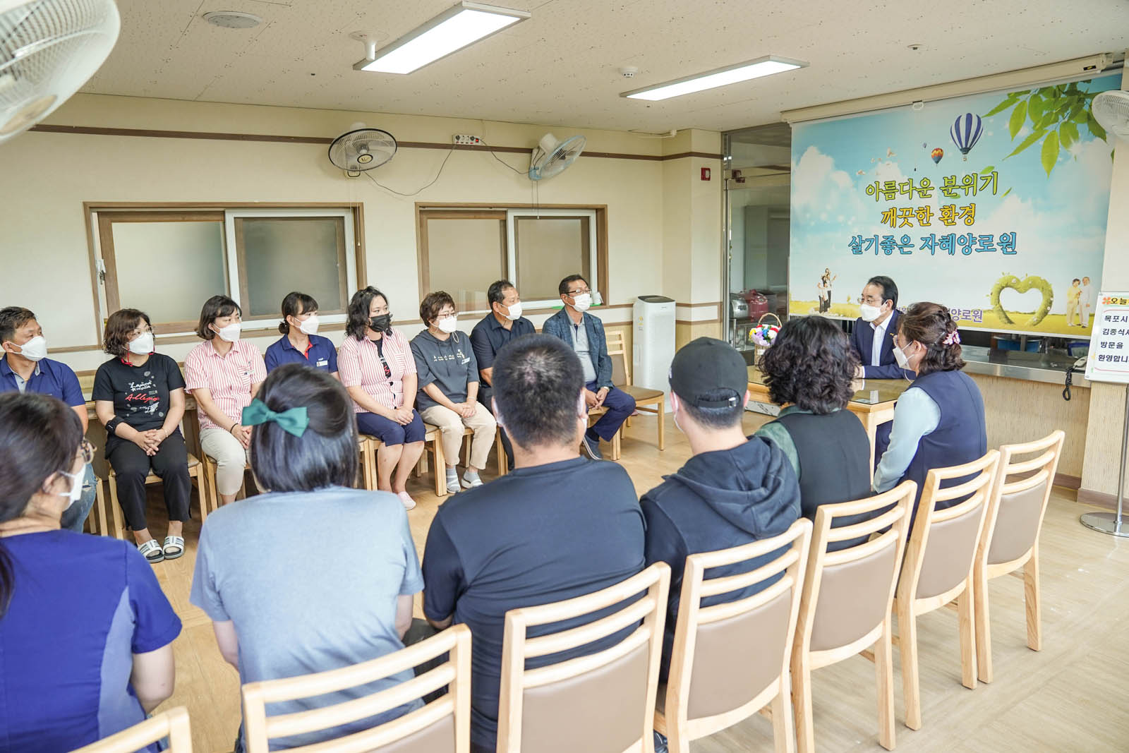 복지시설 관계자들이 시장님을 가운데 모시고 양가로 정렬해 앉아서 시장님과 이야기 나누고 있는 사진이다