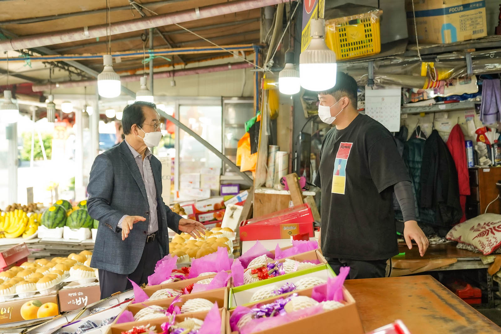 시장님이 청과물 판매 중인 한 상인과 담소나누고 있는 사진이다