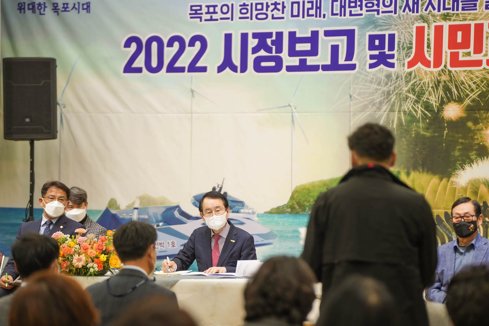 (03.21.종합사회복지관) 시정보고 및 시민과의 대화에서 한 남성이 이야기하고 있고 목포시장이 손에 필기구를 들고 경청하고 있다.