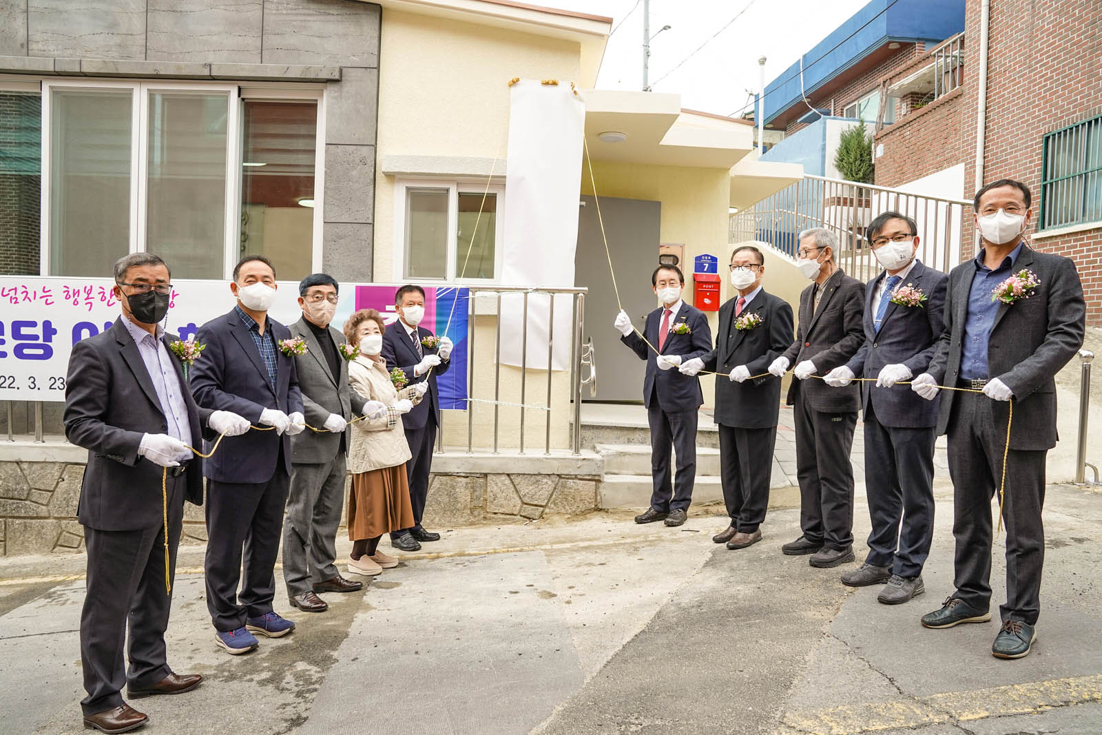 (03.23.연락교회주차장) 목원동 호남경로당 이전 개소식 현판 오픈을 위해 줄을 들고 준비중이다