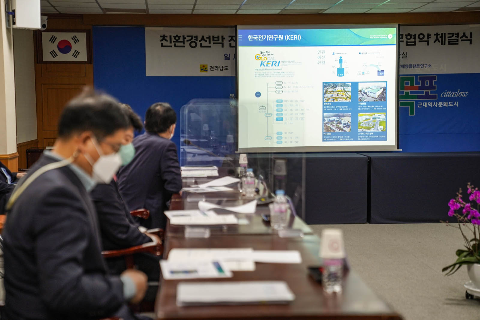 (03.29.상황실) 업무협약 체결식을 진행중인 모습으로 정면 스크린에 있는 자료를 보고 있다.