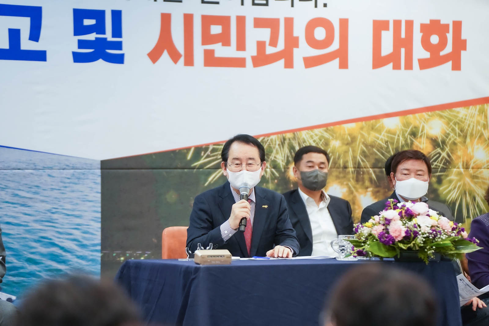(03.30.에메랄드웨딩홀) 시민과의 대화를 나누는 목포시장의 모습이다. 마이크를 들고 웃으며 이야기 하고 있다.