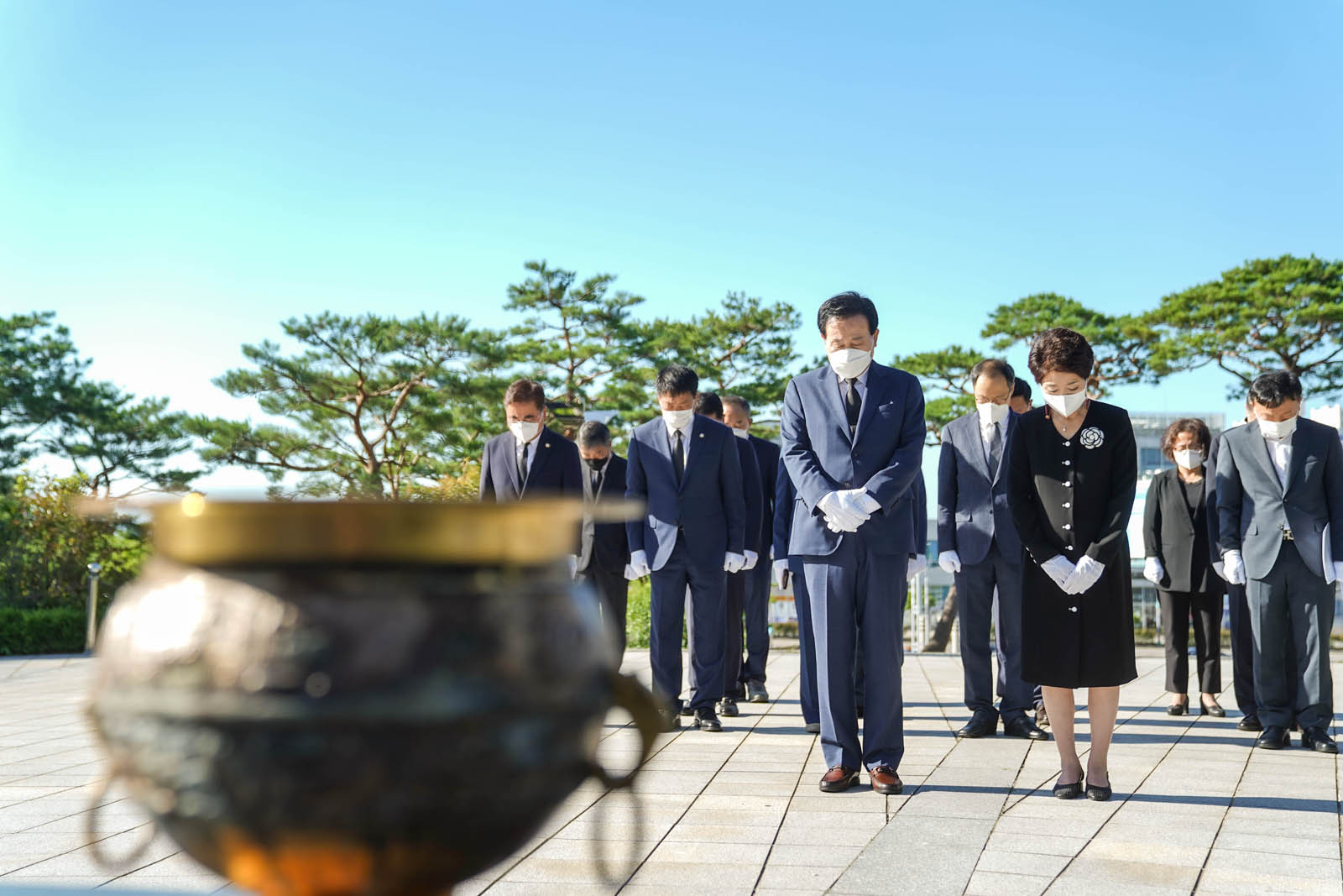 (07.01.현충탑) 목포시장 내외와 모든 참석자들이 묵념하고 있고 정면에 향로가 흐릿하게 보인다.