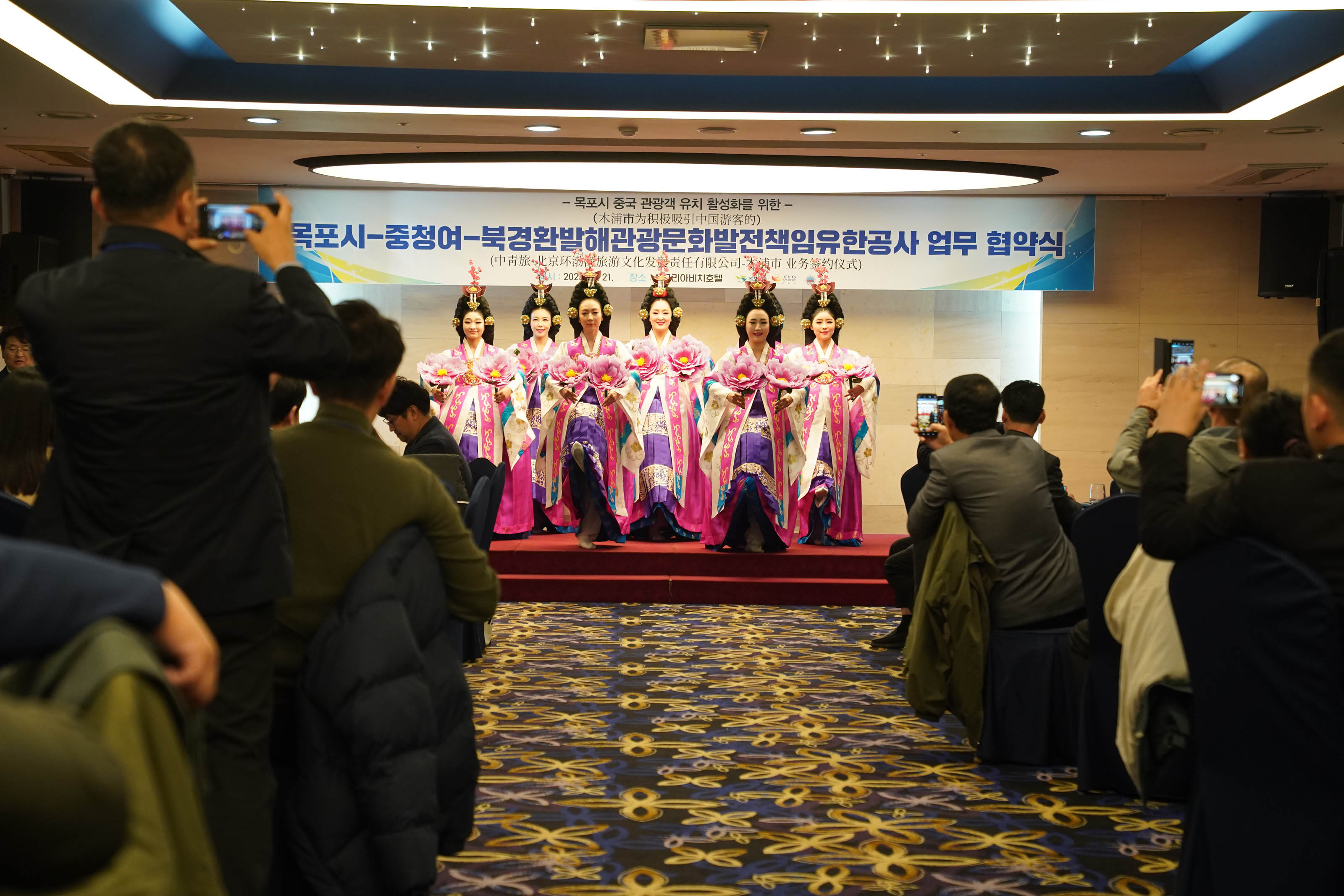 목포시 중국 관광객 유치 활성화를 위한 목포시 중청여 북경환발해관광문화발전책임유한공사 업무 협약식 플랜카드를 뒤에두고 단상위에서 공연하는 모습