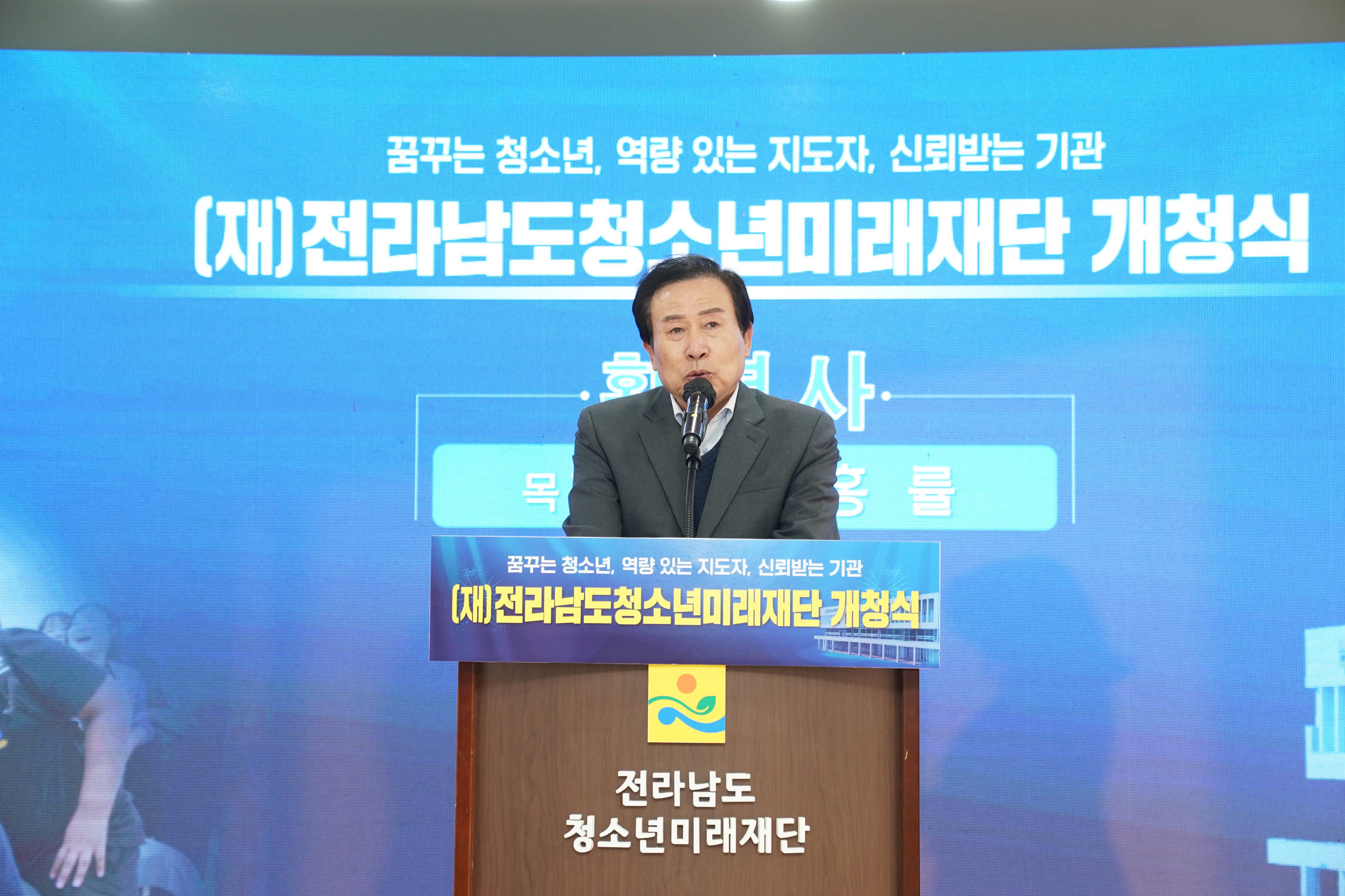 꿈꾸는 청소년, 역량 있는 지도자, 신뢰받는 기관 (재)전라남도 청소년미래재단 개청식 글을 배경으로두고 전라남도 청소년미래재단 단상에서 연설하는 목포시장 박홍률
