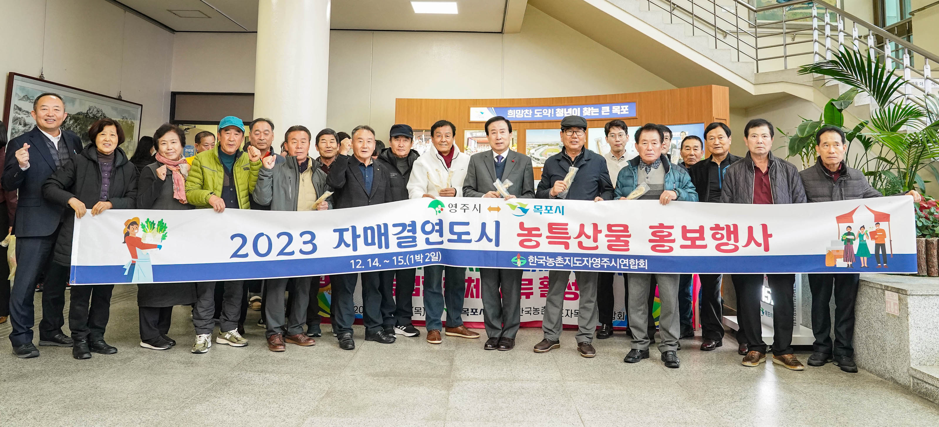 영주시 목포시 2023 자매결연도시 농측산물 홍보행사 플랜카드를 들고 화이팅포즈와 농특산물을 들고 있는 관계자