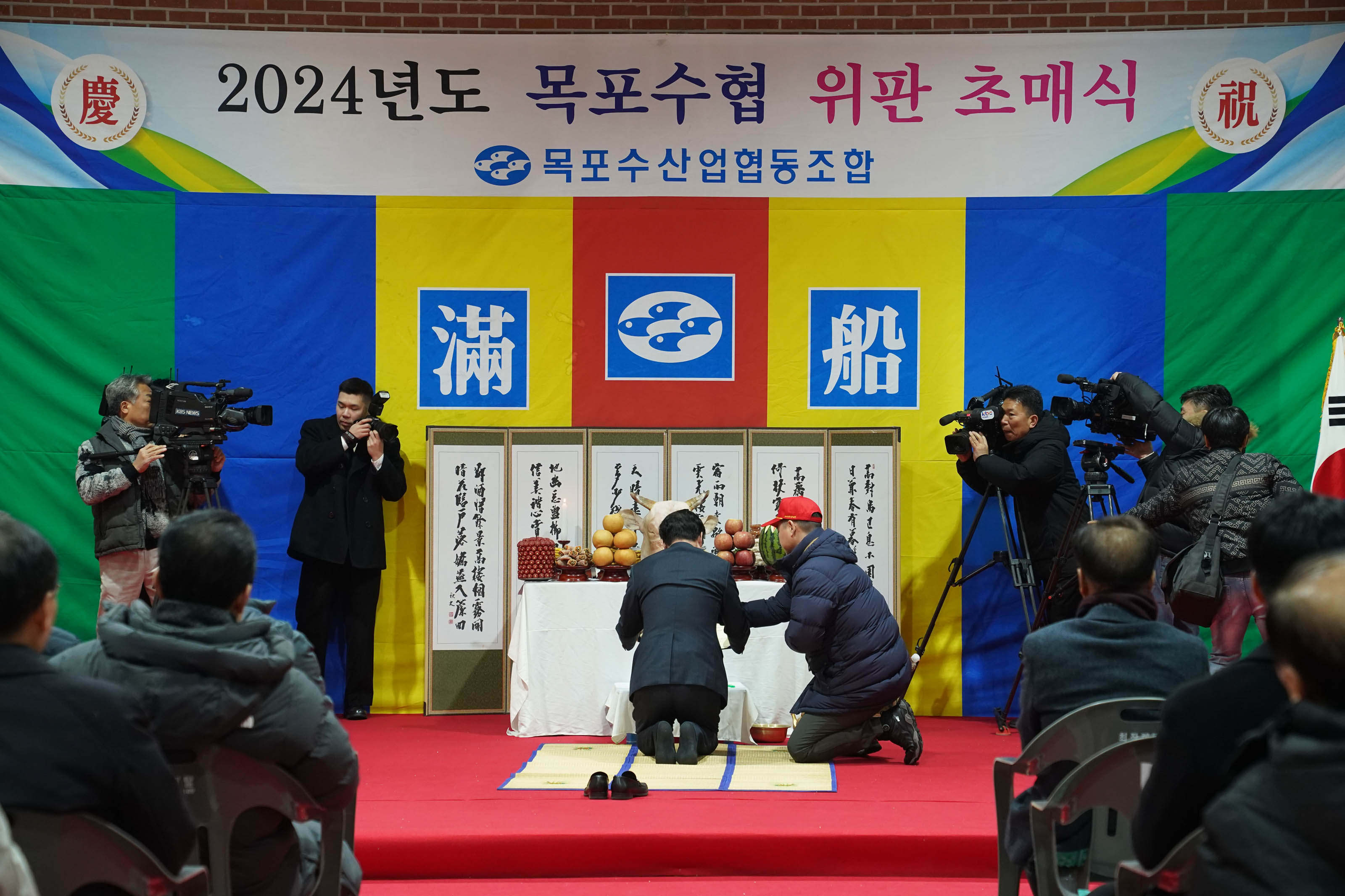 2024년도 목포수협 위판 초매식 목포수산업협동조합 현수막과 지난해 고생많으셨습니다 새해복많이 받으세요 현수막을 배경으로 두고 연단에서 고사를 지내고 있는 모습