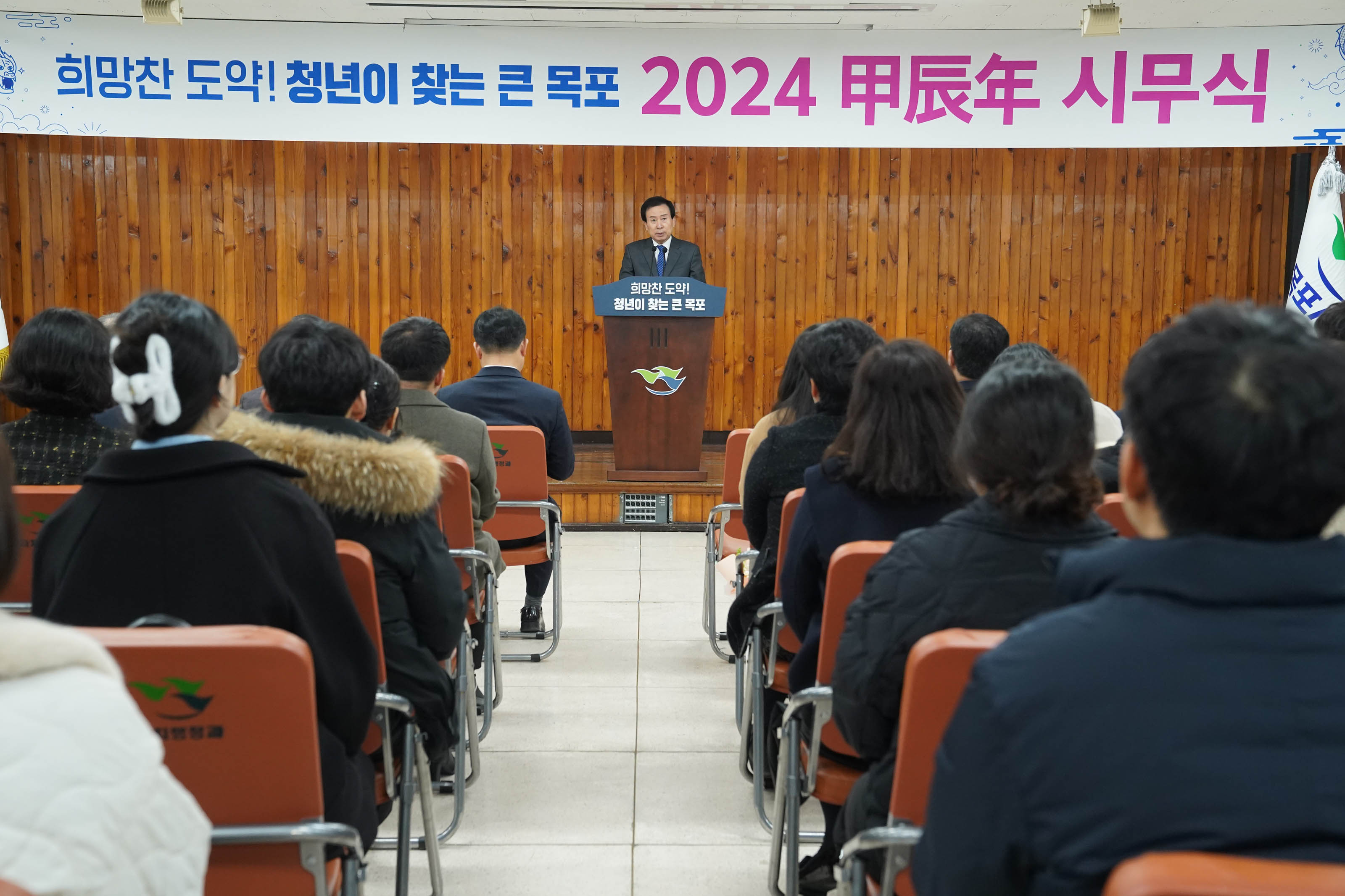 희망찬 도약! 청년이 찾는 큰 목포 2024 甲辰年 시무식 현수막이 걸린 무대위 희망찬도약! 청년이 찾는 큰 목포가 적힌 단상에 서서 연설중인 박홍률 시장과 경청하는 청중