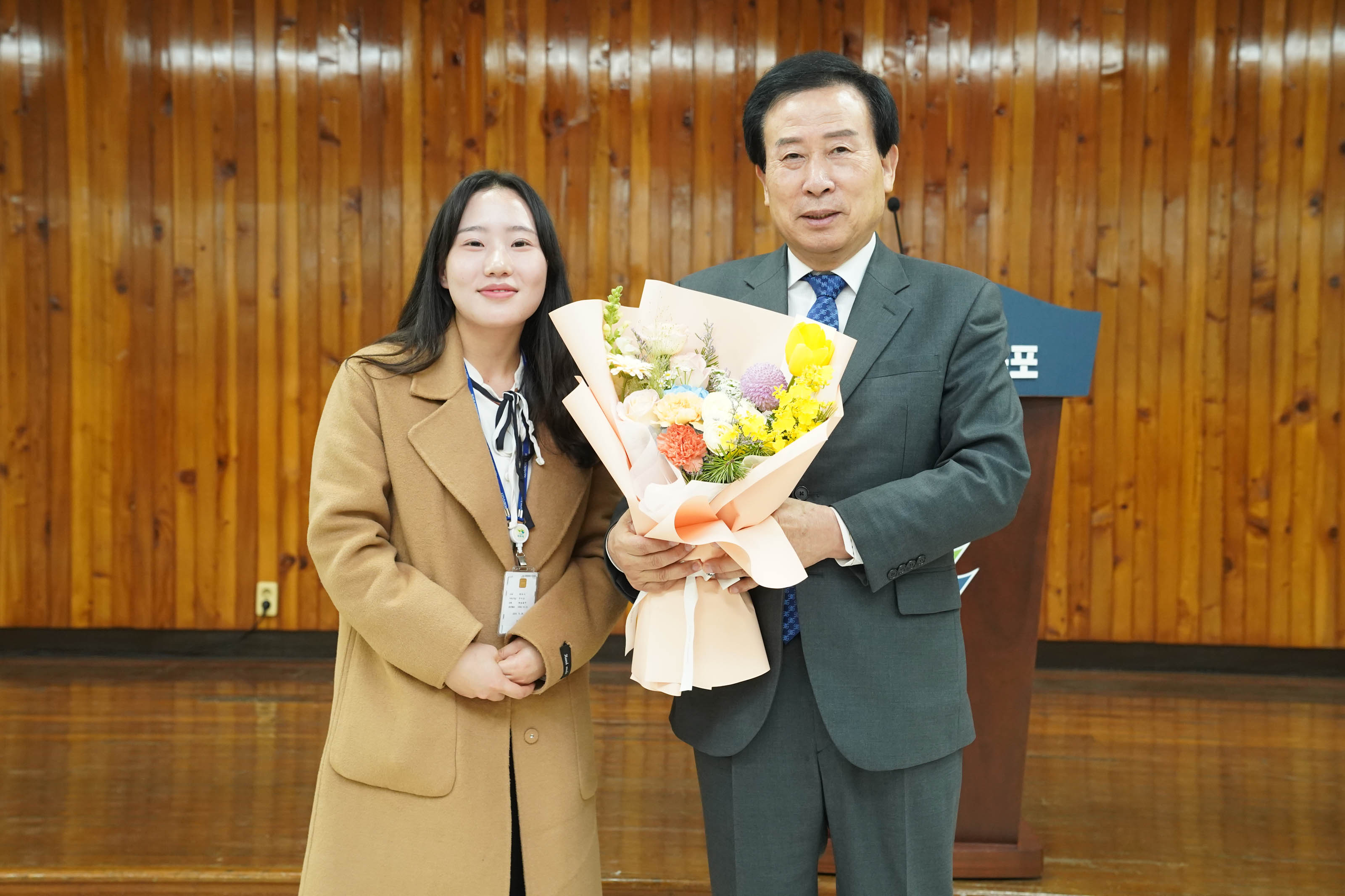 단상앞에서 꽃을 들고 관계자와 사진을 찍는 시장 박홍률