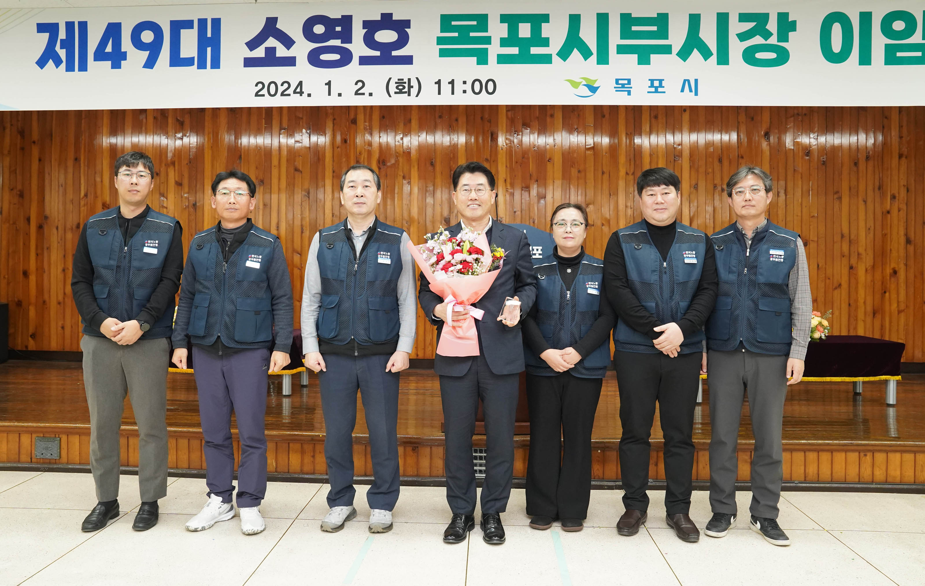 제 49대 소영호 목포시부시장 이임 2024.1.2(화) 11:00 목포시 현수막 앞에서 관계자들과 꽃을 들고 사진찍는 부시장 소영호