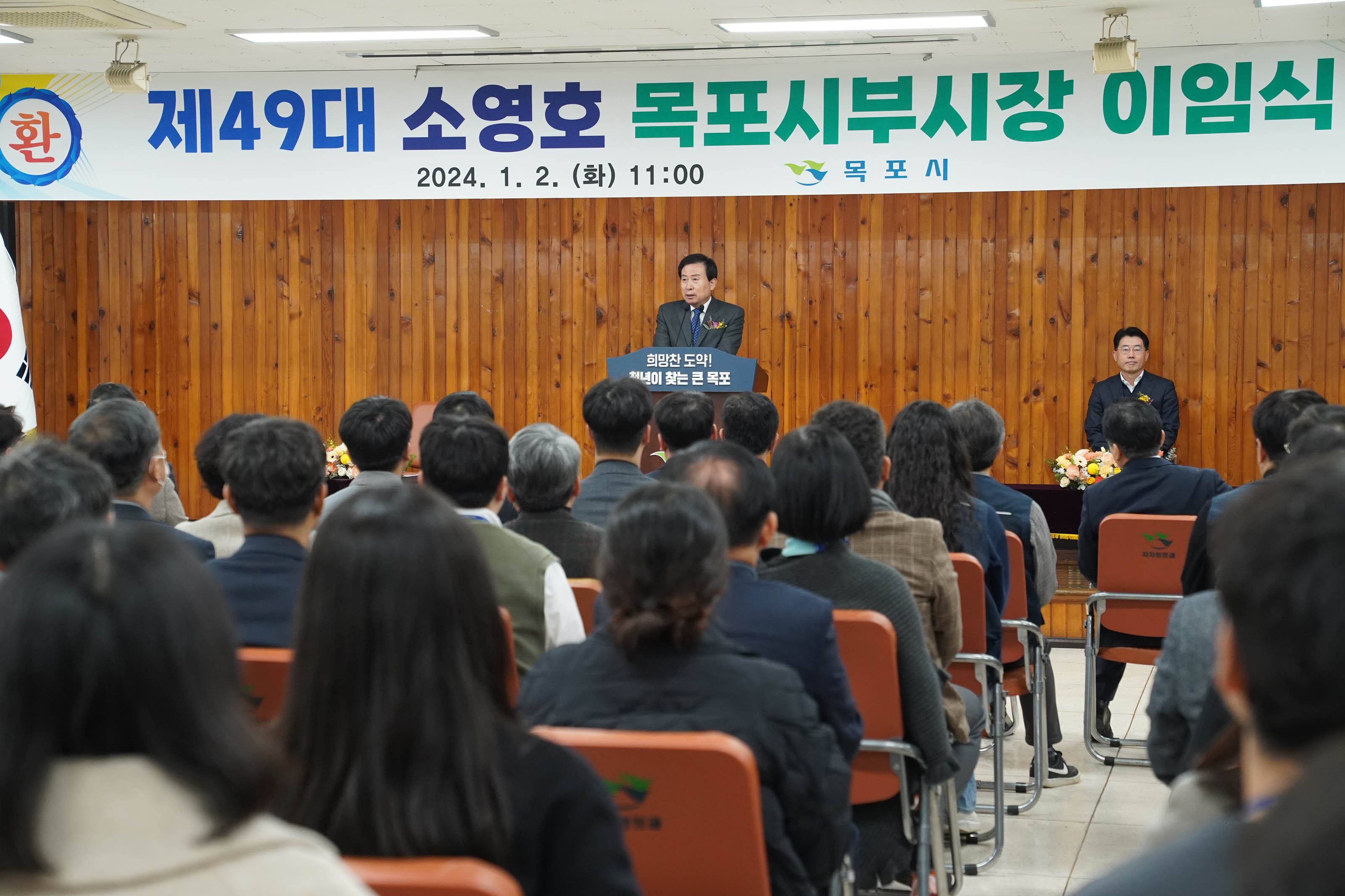 제 49대 소영호 목포시부시장 이임 2024.1.2(화) 11:00 목포시 현수막이 걸린 연단위에서 희망찬 도약! 청년이 찾는 큰 목포 단상위에서 연설중인 박홍률 시장과 경청하는 청중