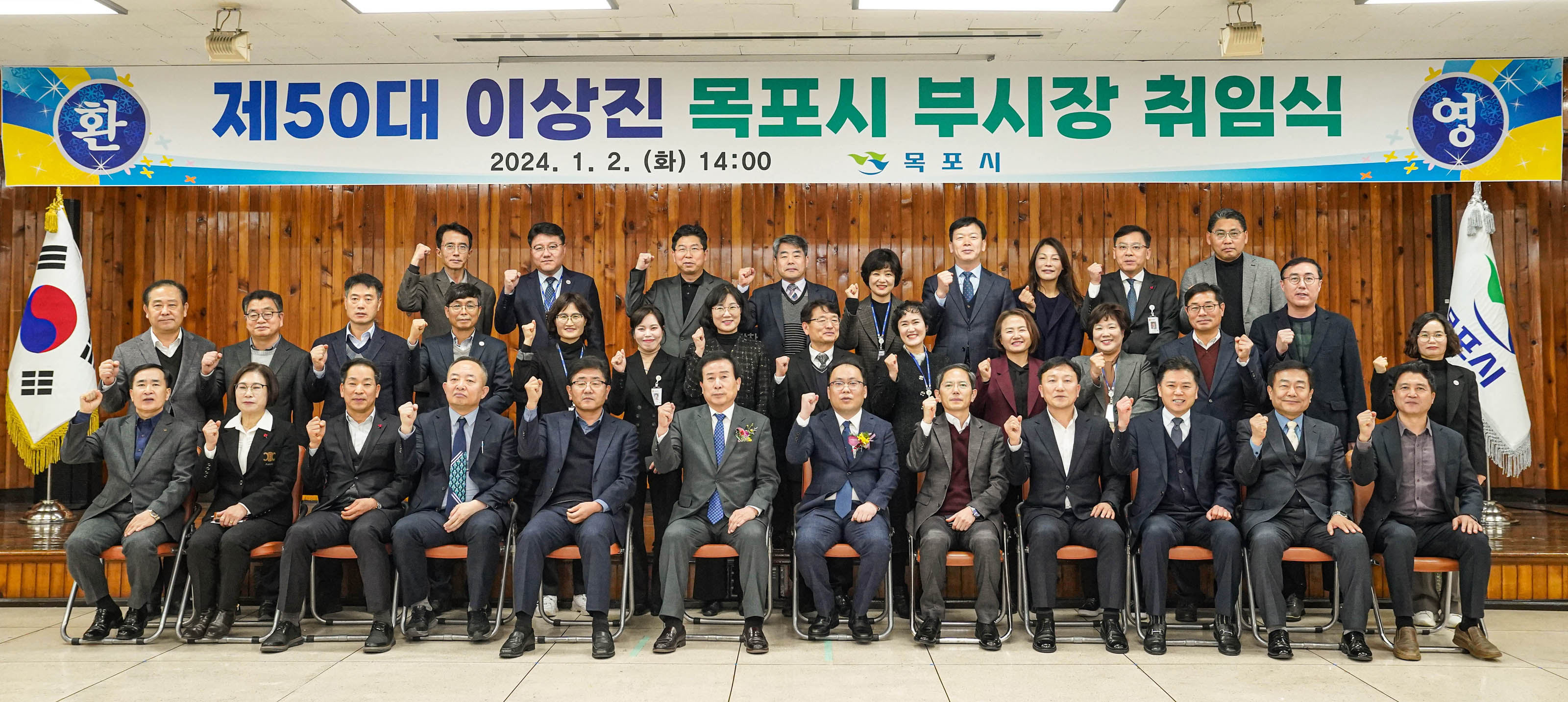 제 50대 이상진 목포시 부시장 취임식 환영 2024.1.2(화) 14:00 목포시 현수막이 걸린 연단아래에서 관계자 모두 화이팅 포즈를 취하는 모습