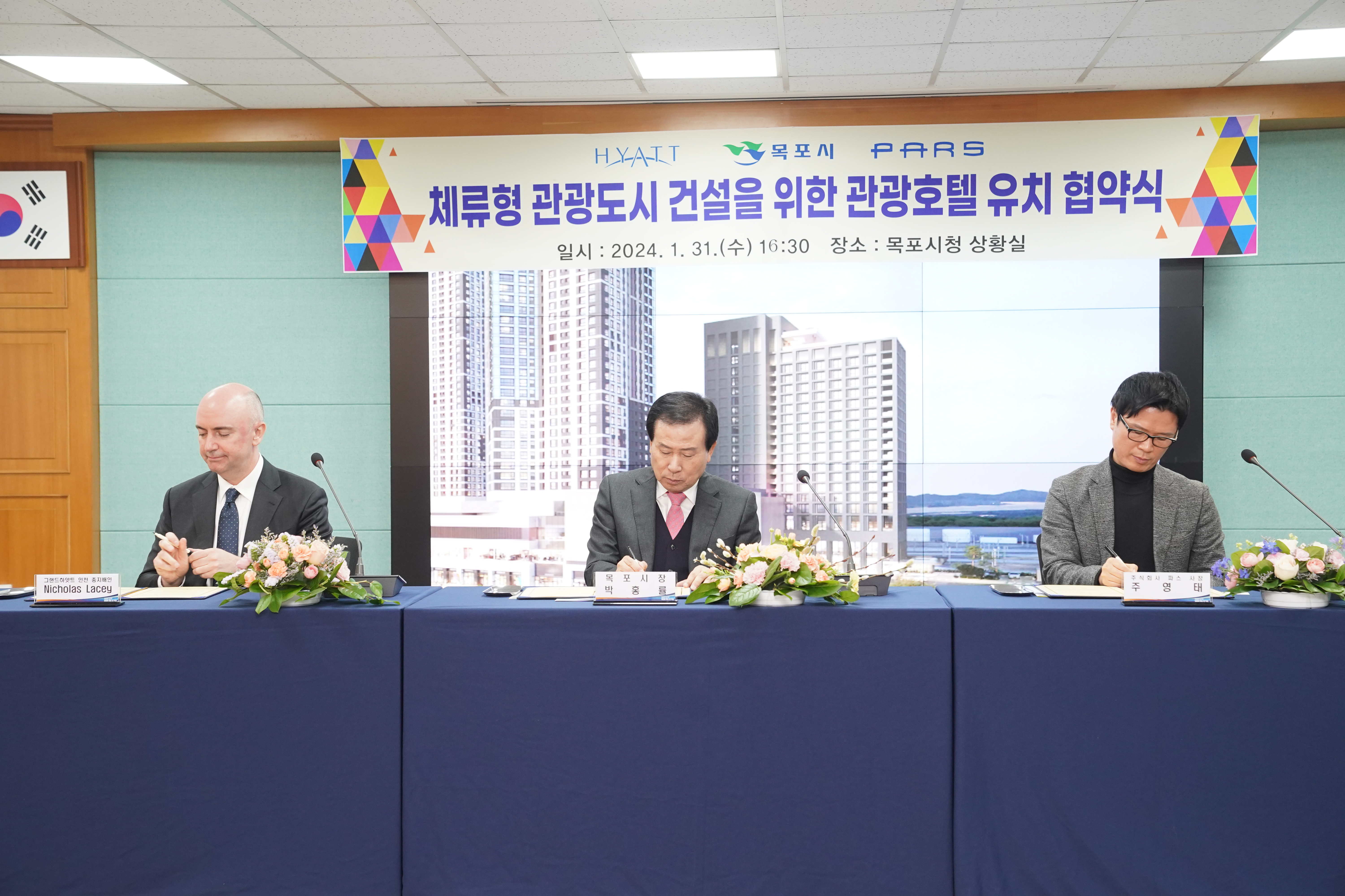 HYATT 목포시 PARS체류형 관광도시 건설을 위한 관광호텔 유치 협약식 일시 : 2024. 1. 31(수) 16:30 장소 : 목포상황실 현수막 아래에서 필기하고있는 모습의 박홍률시장과 관계자