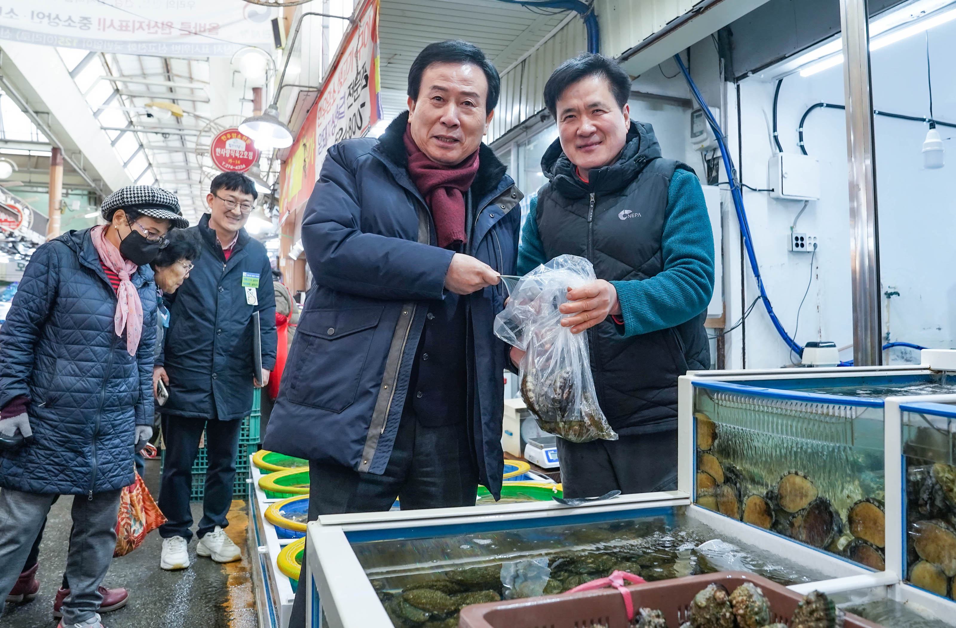 구매할 해산물을 들고 상인과 함께 사진찍는 모습.