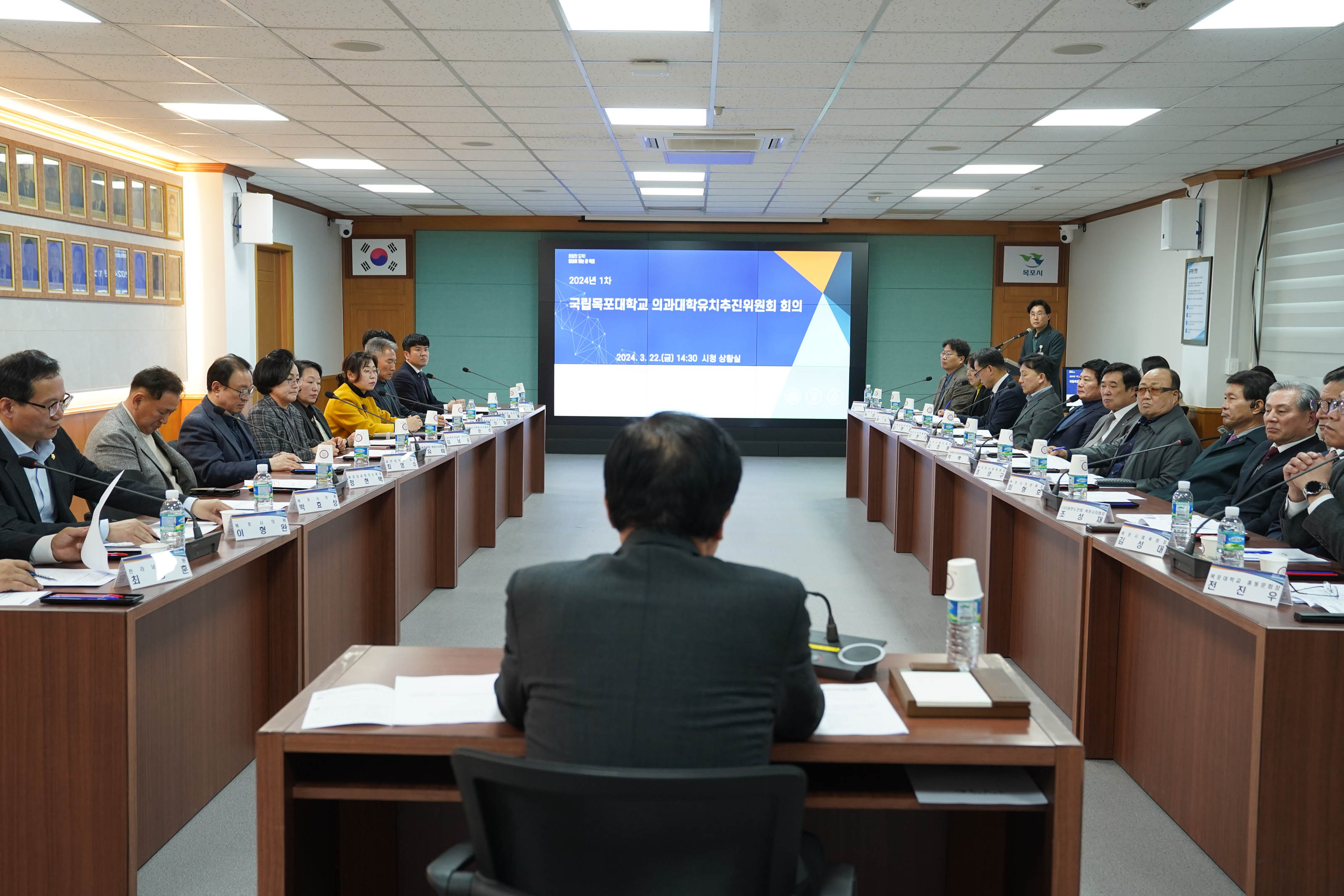 2024년 1차 국립목포대학교 의과대학유치추진위원회 회의 2024.3.22(금) 14:30 시청 상황실 화면을 마주하고 있는 박홍률 시장의 뒷모습과 회의에 참석한 20명 정도의 위원들의 모습이 전체적으로 보인다