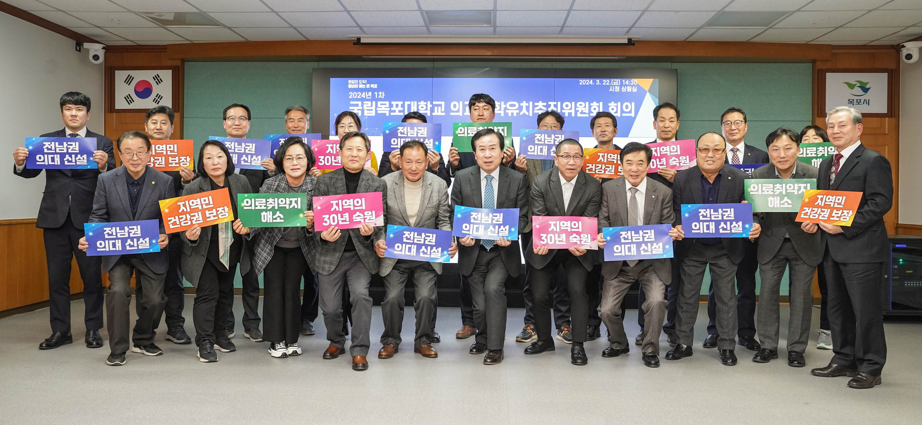 전남권 의대 신설이 적힌 파란색 플랜카드, 지역민 건강권 보장이 적힌 주황색 플랜카드, 의료취약지 해소가 적힌 초록색 플랜카드, 지역의 30년 숙원이 적힌 분홍색 플랜카드를 각각 손에 쥔 박홍률 시장과 위원들의 단체 사진