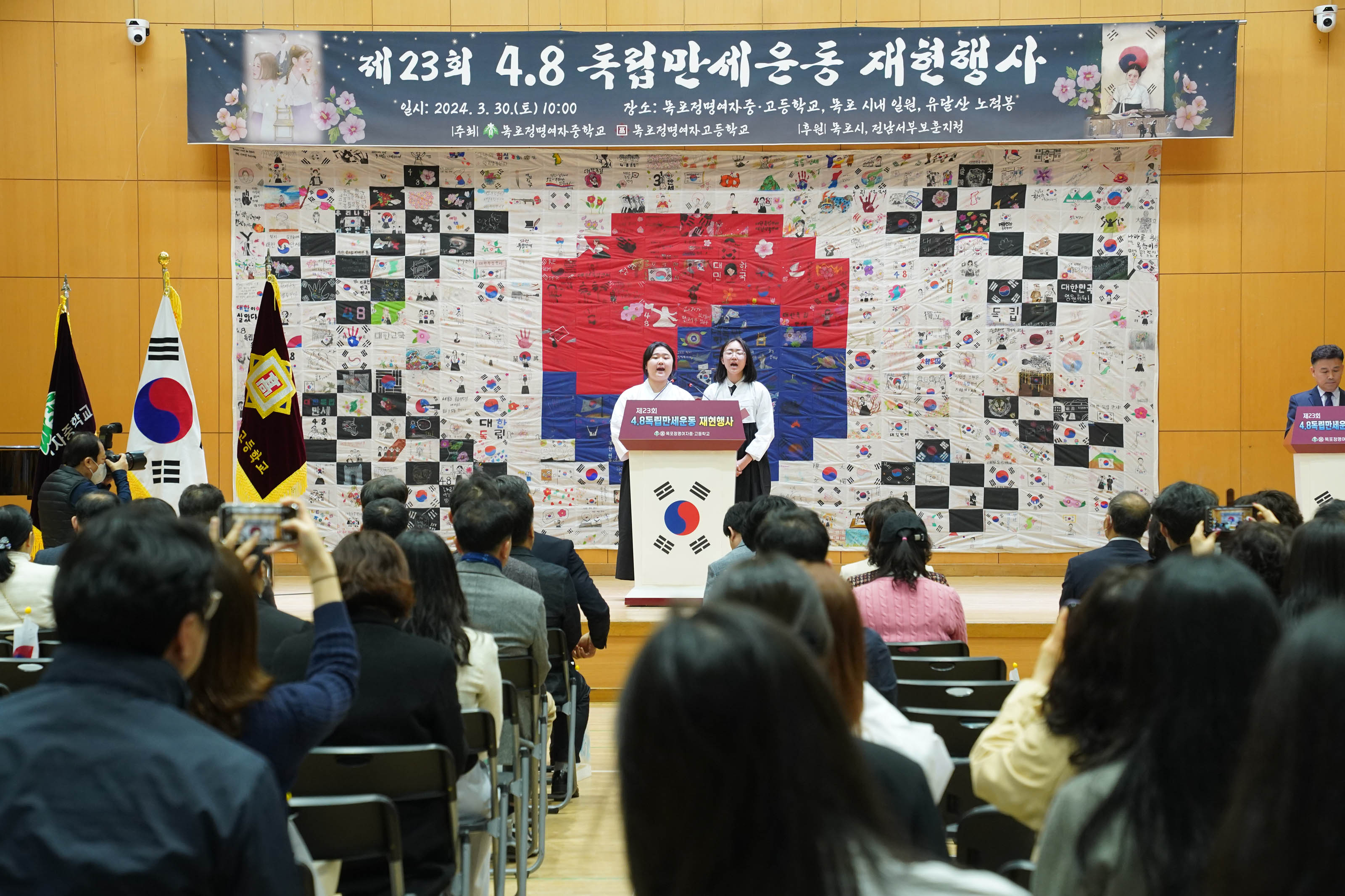 제23회 4.8 독립만세운동 재현행사 일시 2024.3.30(토)10:00 장소:목포정명여자중,고등학고, 목포 시내 일원, 유달산 노적봉 주최 목포정명여자중학교 목포정명여자고등학고 후원 목포시, 전남서부보훈지청 현수막이 걸려 있고, 흰색 윗도리에 검은색 치마를 입은(유관순 열사 복장) 두 명의 여학생이 단상에 서서 발표를 하고 있다.