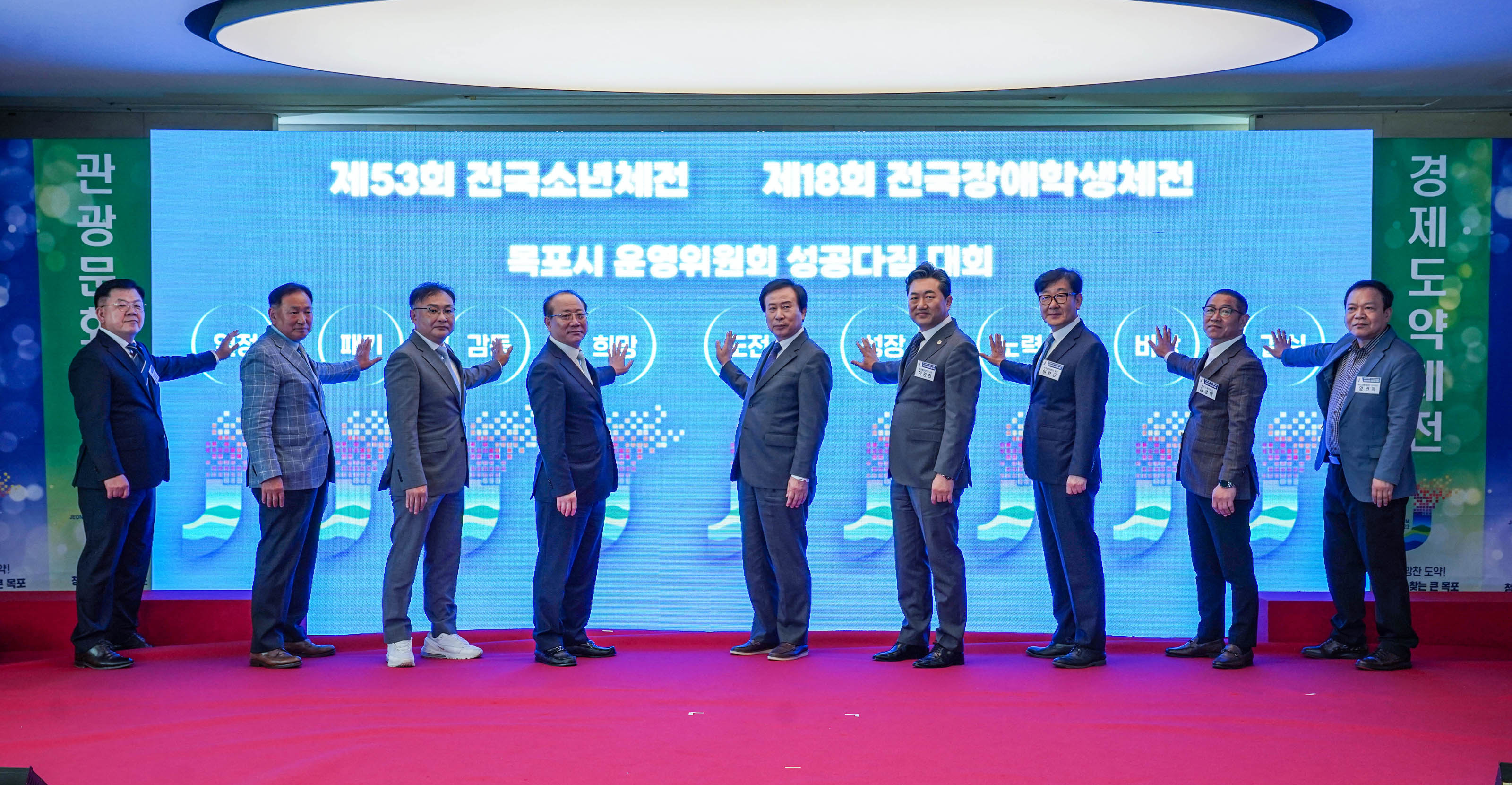 제53회 전국소년체전 제18회 전국장애학생체전 목포시 운영위원회 성공다짐 대회 글귀를 배경으로 각각 인정,패기,감동,희망,도정,성장,노력 등의 글귀마다 손을올리고 사진을 찍는 관계자들과 박홍률시장