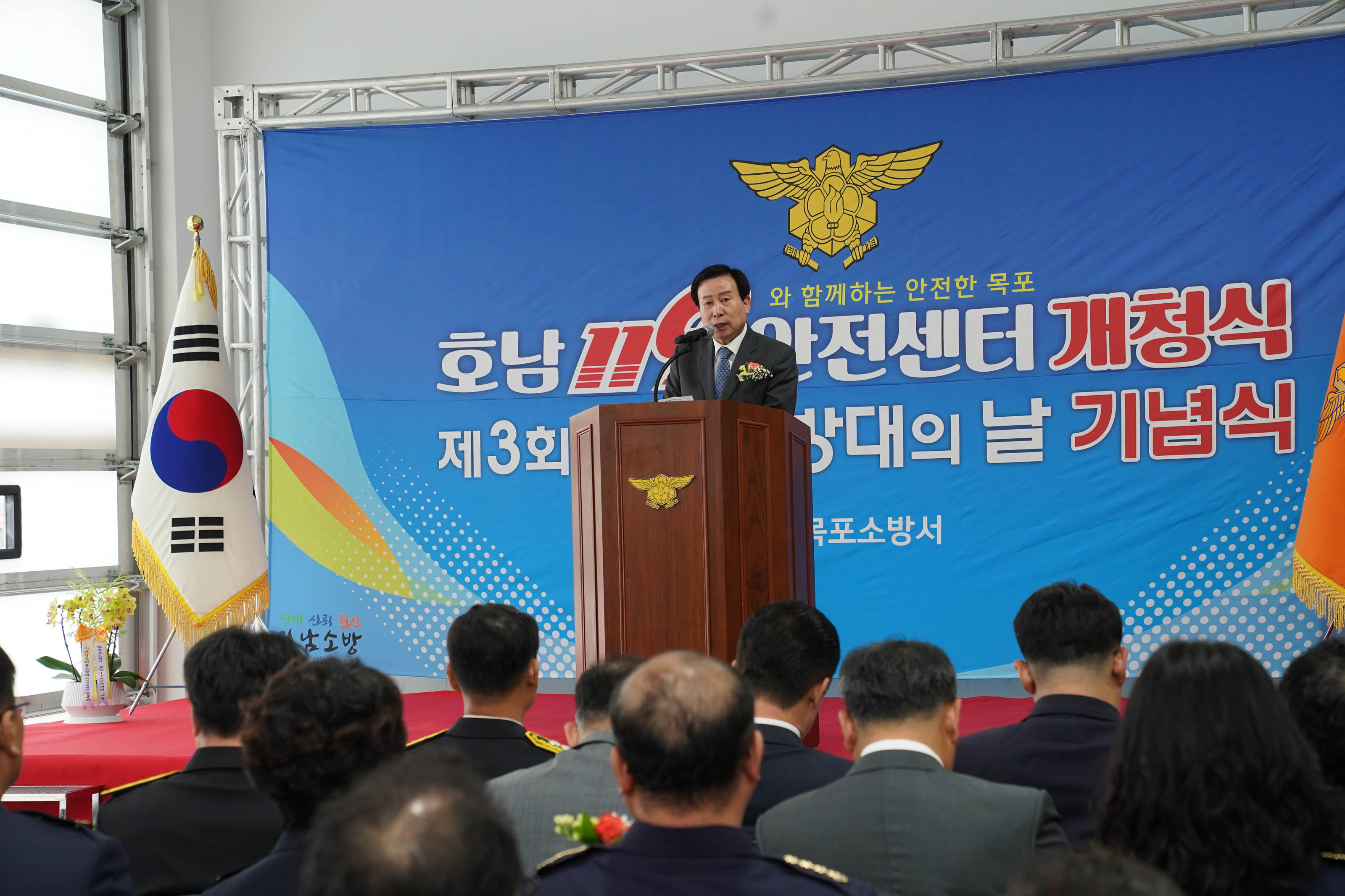 호남 119와 함께하는 안전한 목포 안전센터 개청식 제3회 의용소방대의 날 기념식 목포소방서 현수막을 배경으로하고 단상위에서 연설하고있는 박홍률 시장과 경청하는 관계자들
